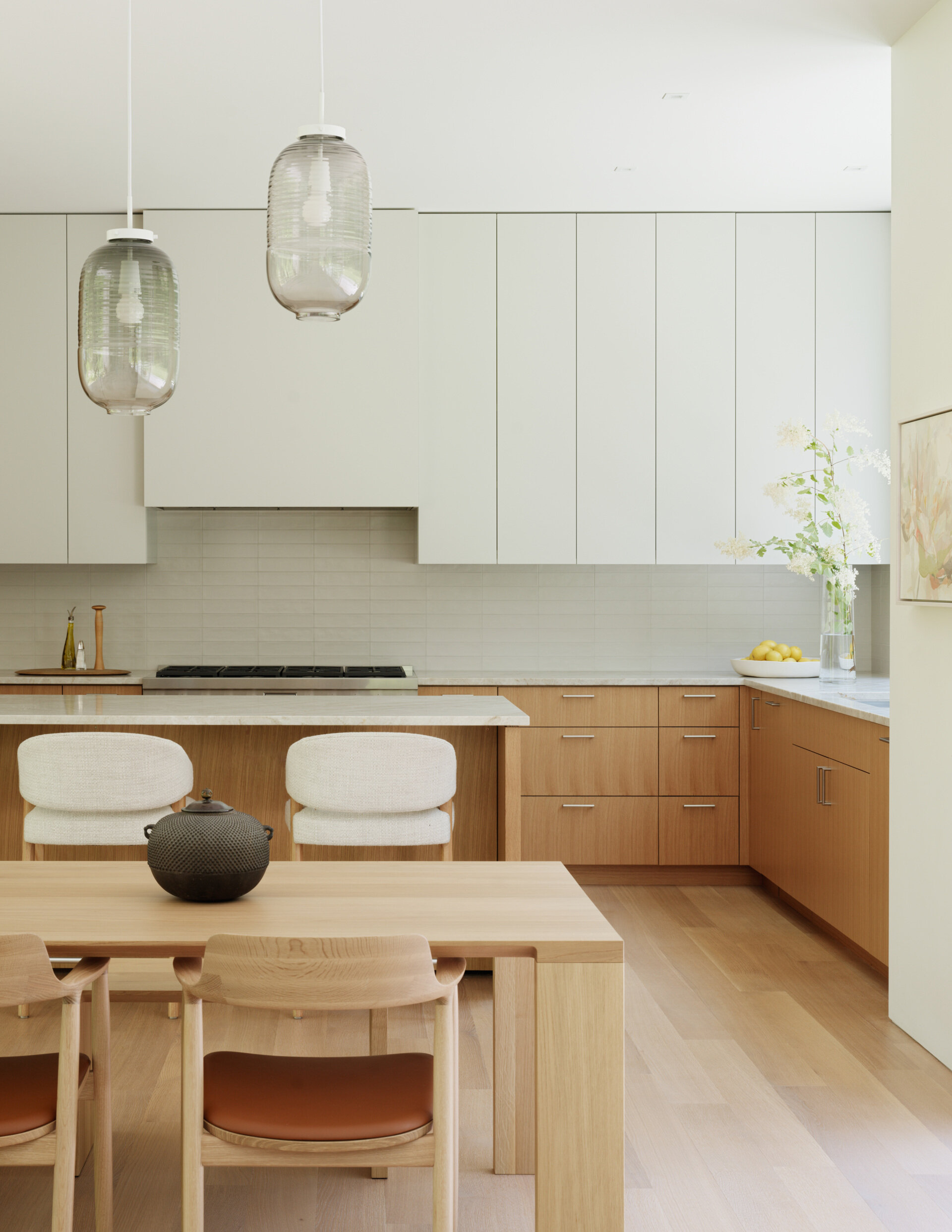 The kitchen is designed for daily use and family gatherings alike. A neutral palette of light-toned wood,  and matte finishes creates a feeling of calm utility. Open sightlines to the rest of the living wing keep the space connected, while durable surfaces and practical layouts support a busy lifestyle. 