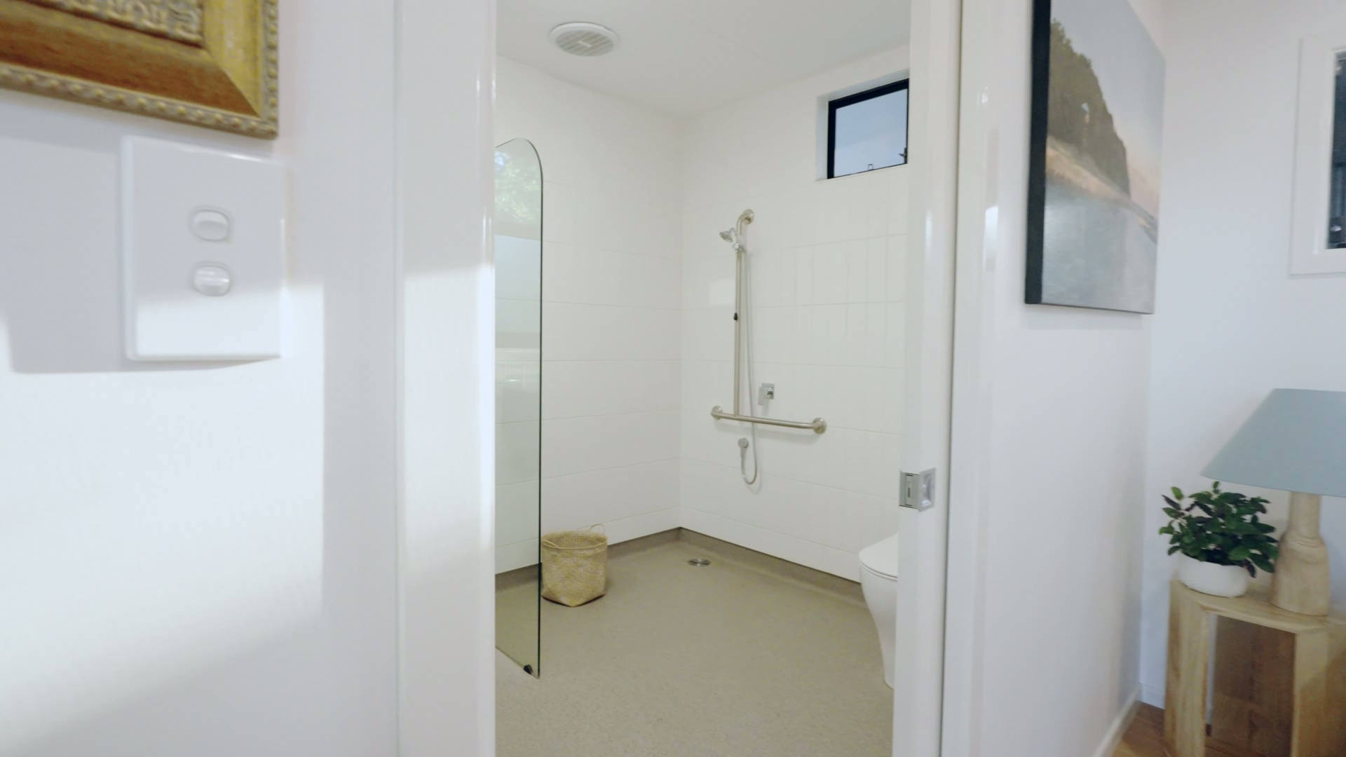 A spacious, accessible bathroom and laundry room with a wet-room shower and plenty of storage.
