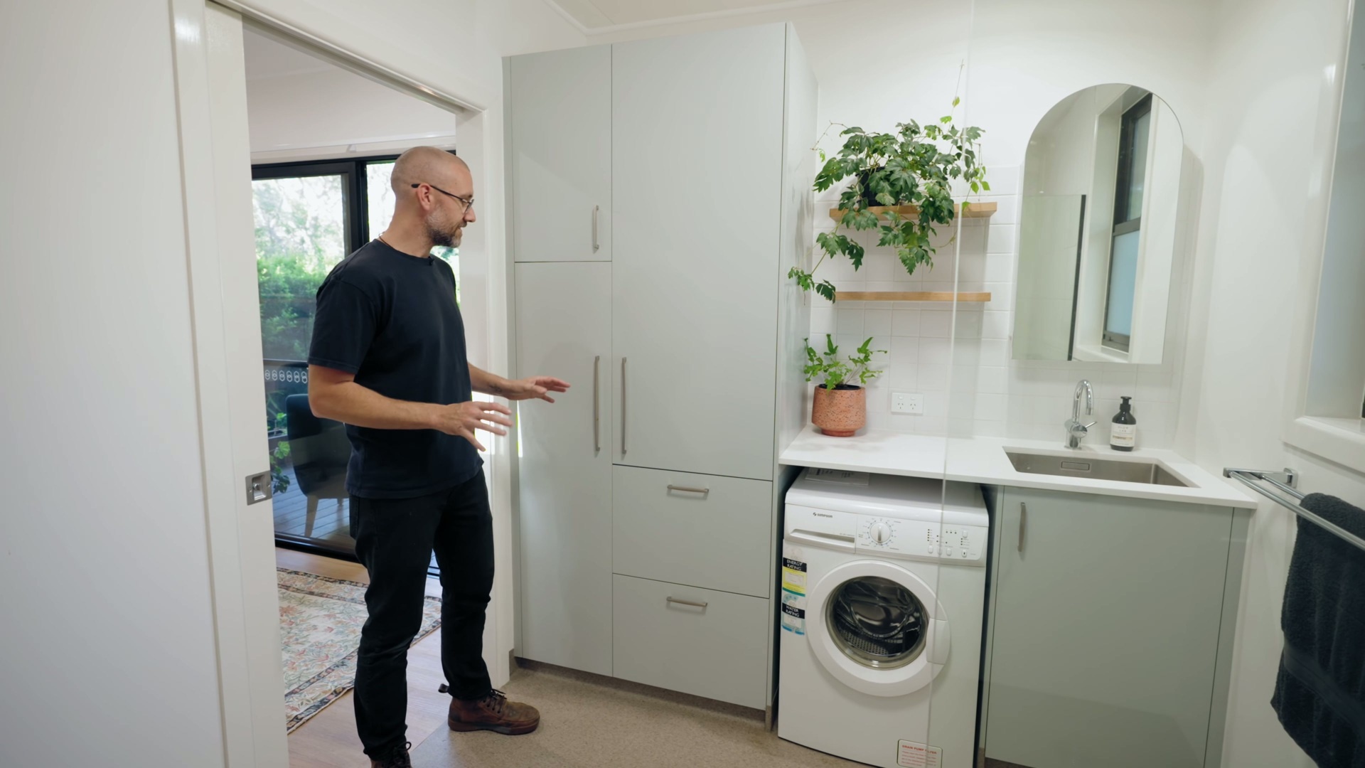 A spacious, accessible bathroom and laundry room with a wet-room shower and plenty of storage.