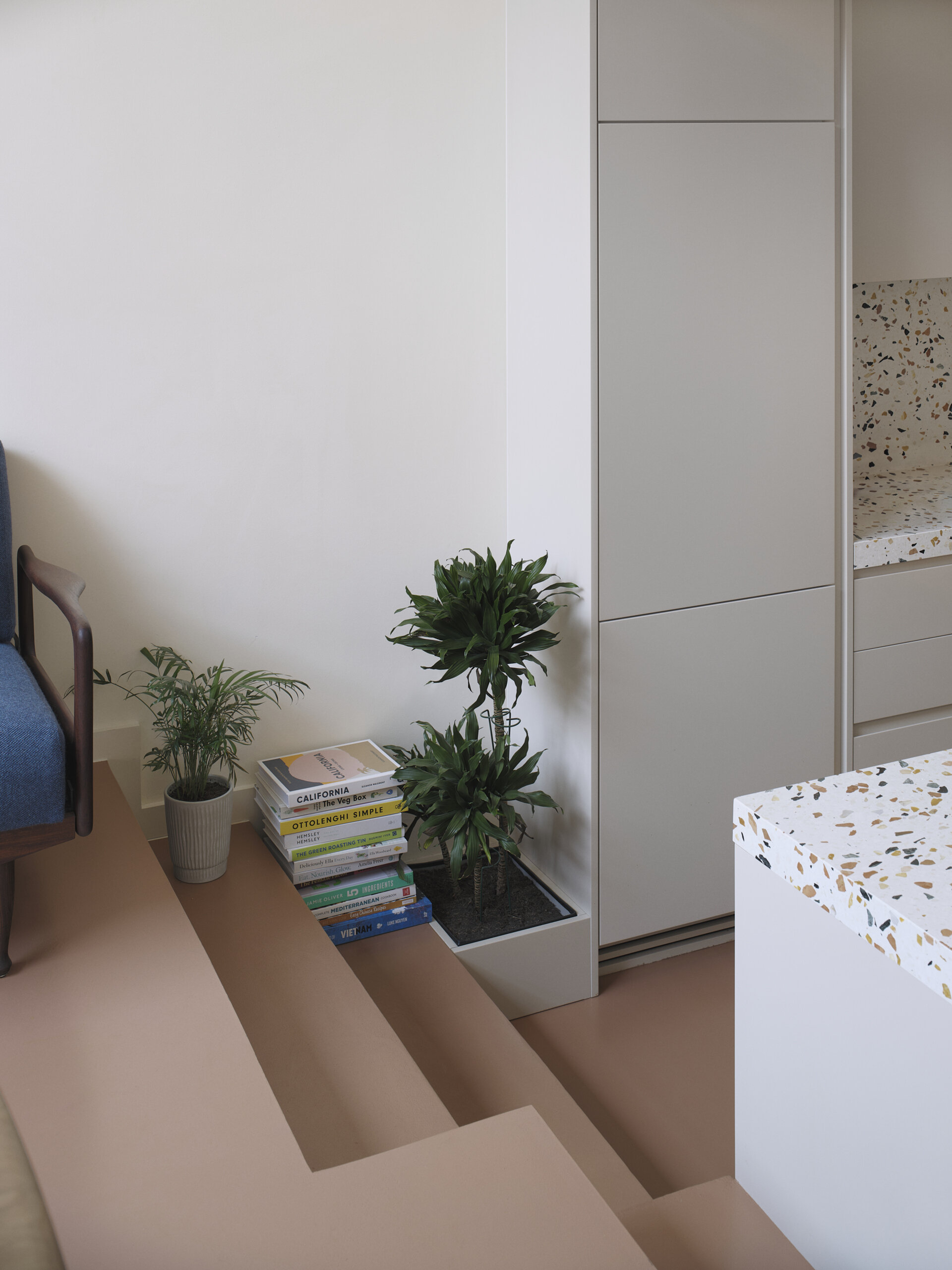 The kitchen and dining areas of this home are arranged across different levels, with a short set of steps subtly marking the transition between the two. This change in height gives each zone its own identity while maintaining a visual connection.