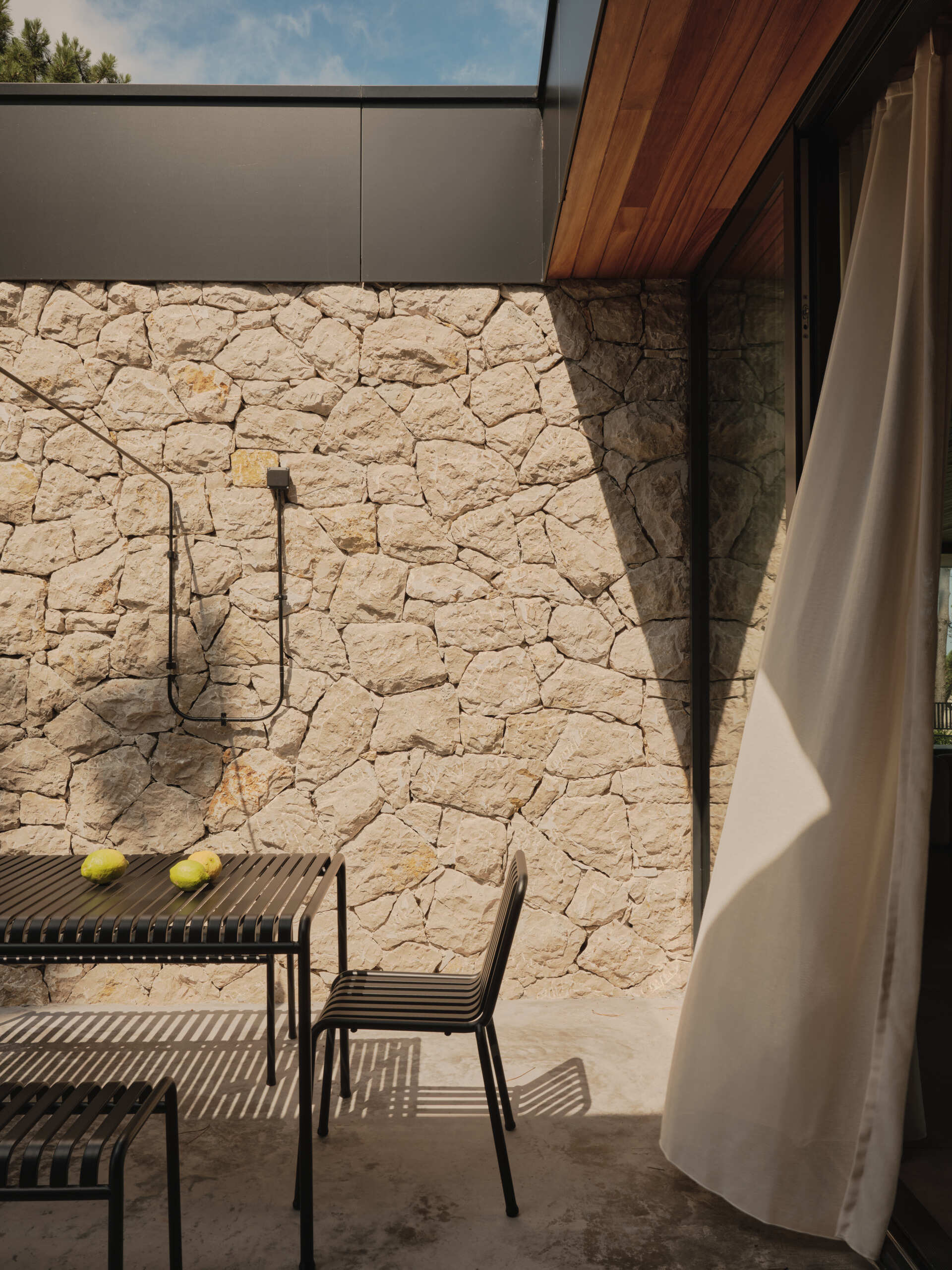 Sheltered outdoor spaces are woven into the design of the home as a response to the often-harsh coastal climate. Porches and eaves provide cover from wind and rain, while allowing residents to dine alfresco.