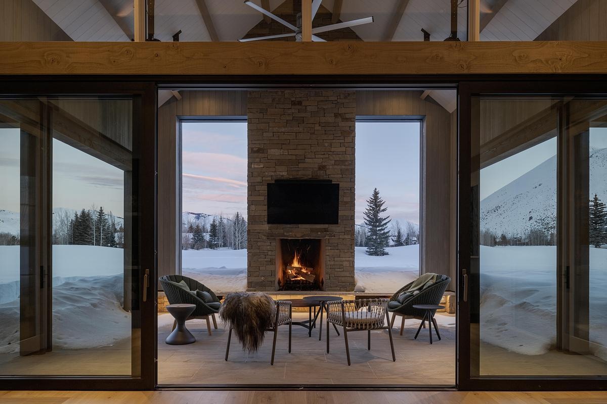 This understated outdoor living room with a fireplace anchors a quiet garden space, perfect for evening gatherings and year-round comfort.