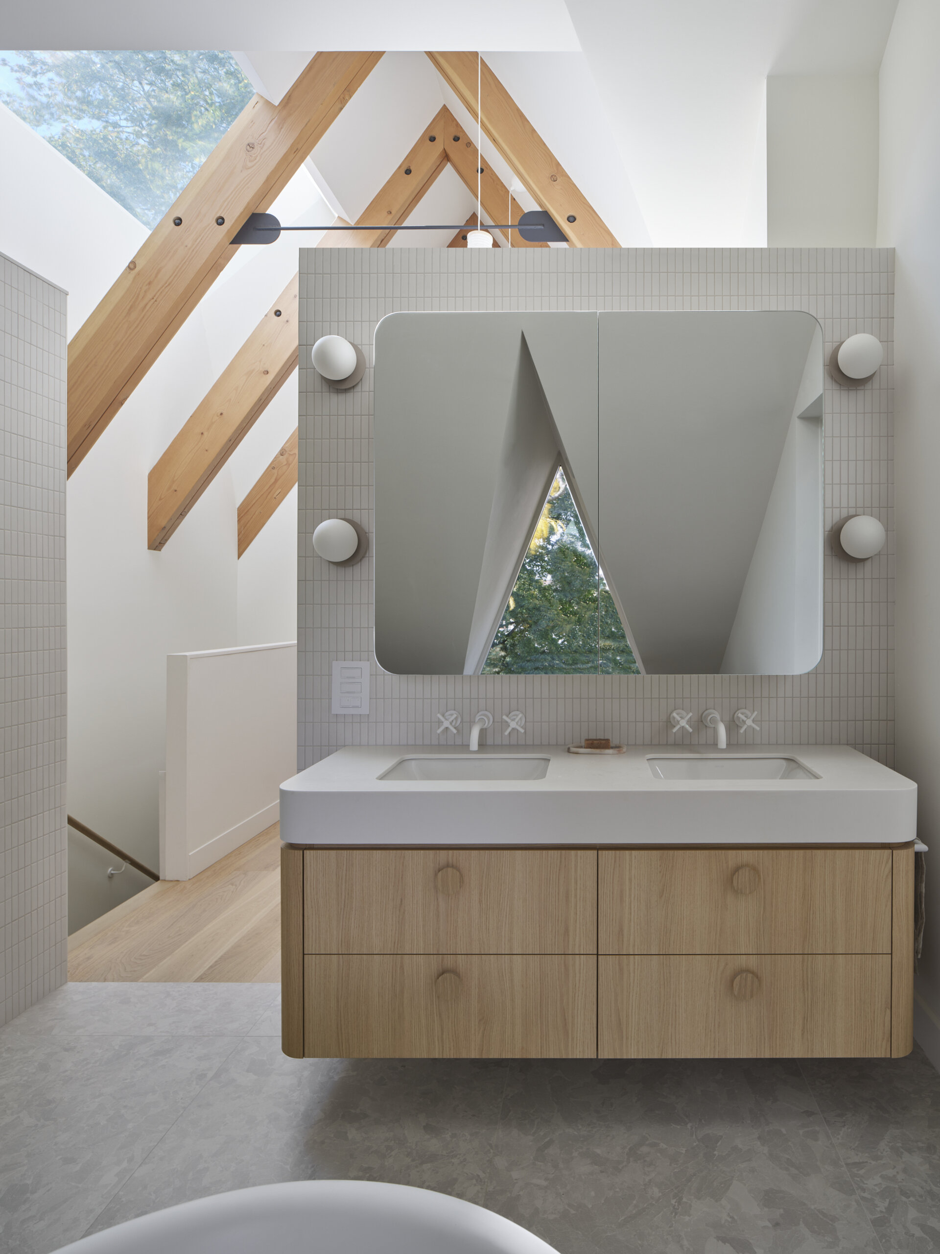 Natural stone, warm wood, and gentle daylight define this serene ensuite bathroom designed for daily retreat.