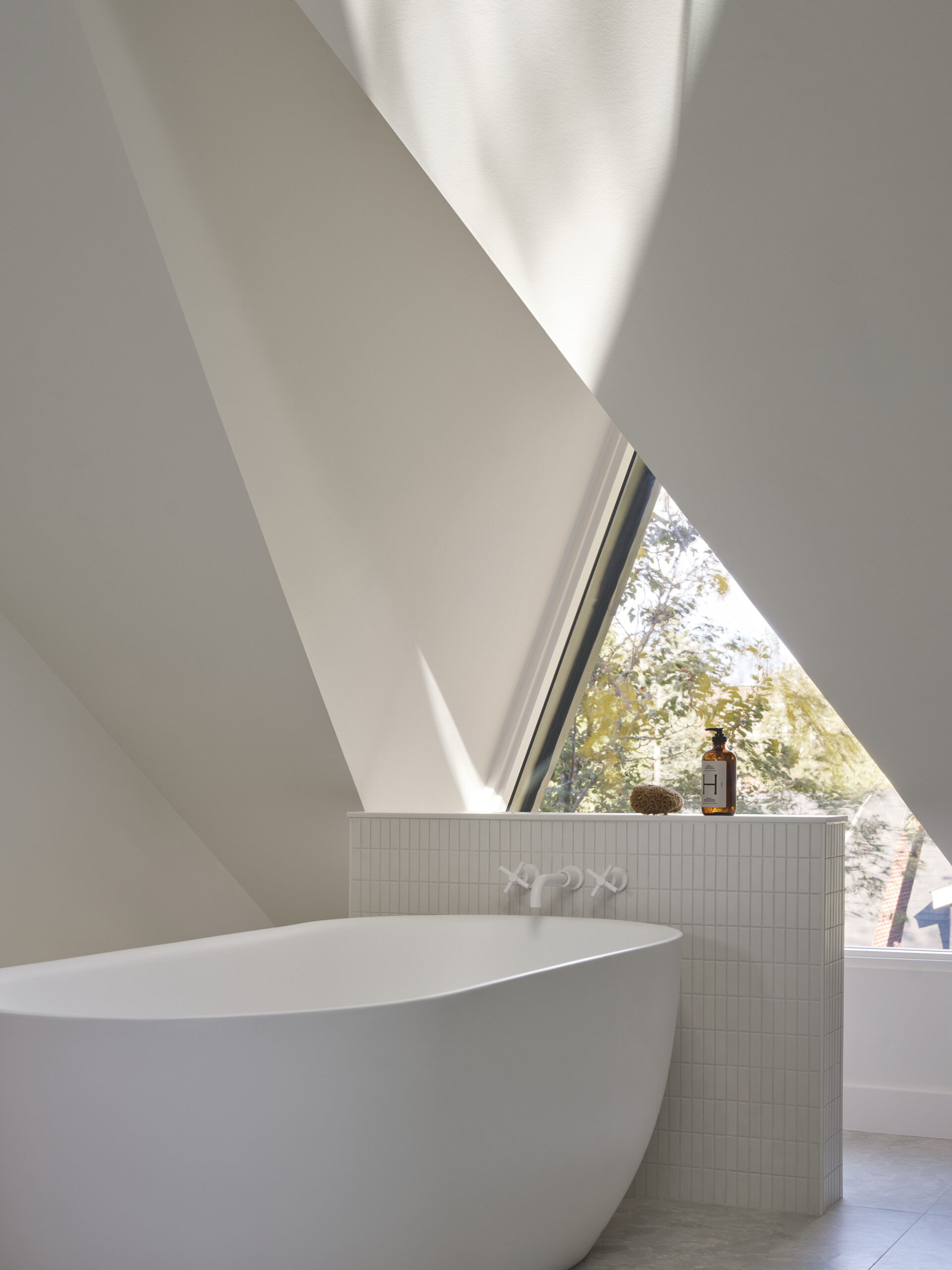 Natural stone, warm wood, and gentle daylight define this serene ensuite bathroom designed for daily retreat.