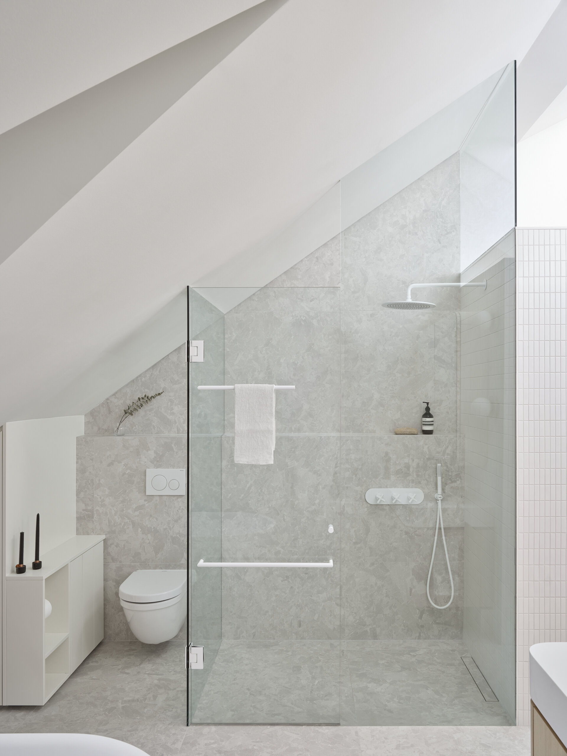 Natural stone, warm wood, and gentle daylight define this serene ensuite bathroom designed for daily retreat.