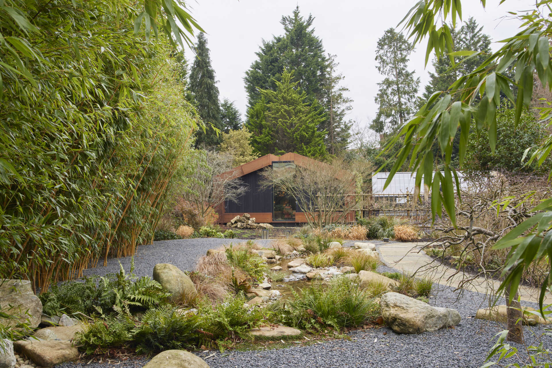 This modern music pavilion blends charred timber, Corten steel, and a living roof to create a sculptural retreat in the landscape.