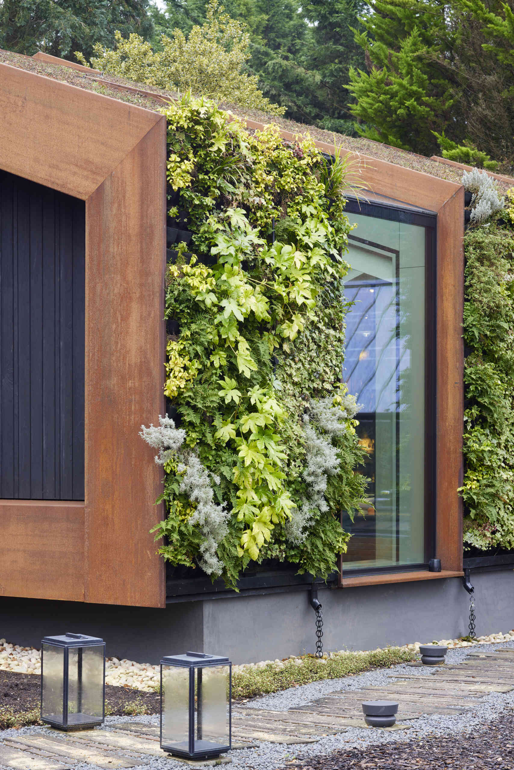 This modern music pavilion blends charred timber, Corten steel, and a living roof to create a sculptural retreat in the landscape.