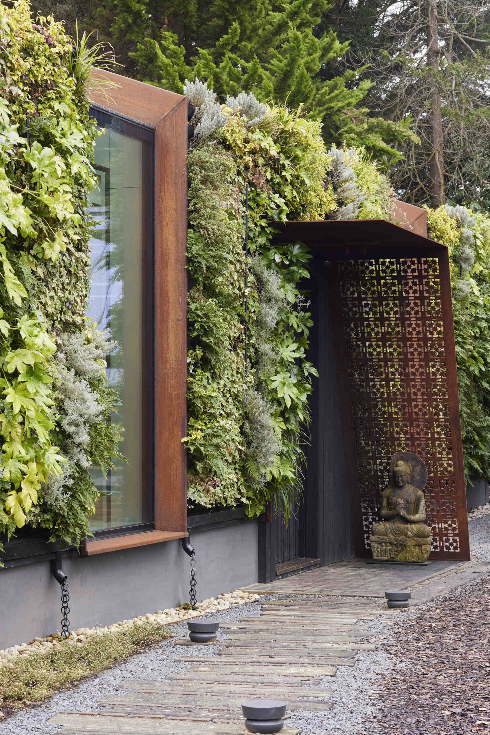 This modern music pavilion blends charred timber, Corten steel, and a living roof to create a sculptural retreat in the landscape.