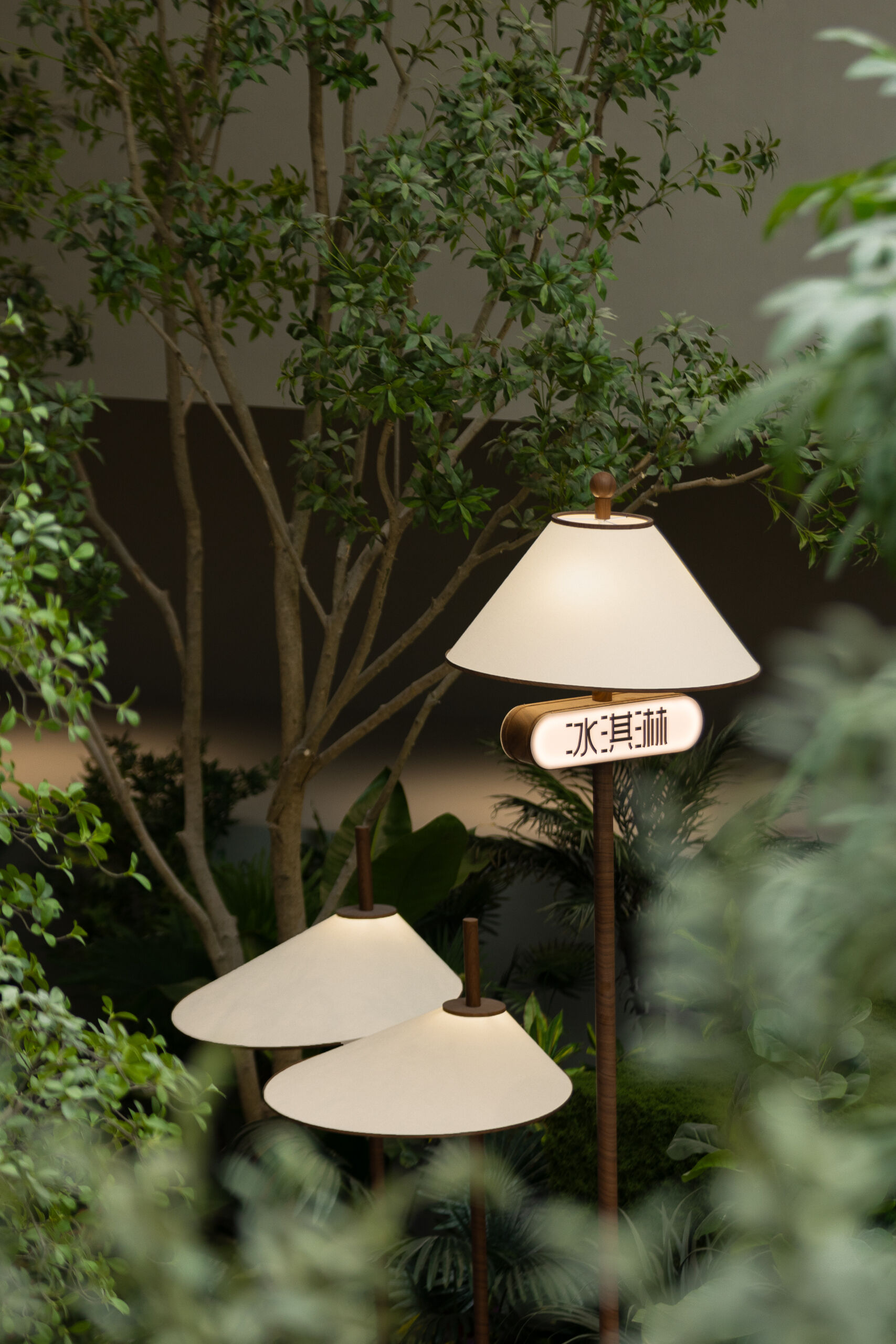 Floor lamps with wooden bases and soft fabric shades blend beautifully with the surrounding greenery. Thoughtful lighting that feels like part of the landscape, not apart from it.