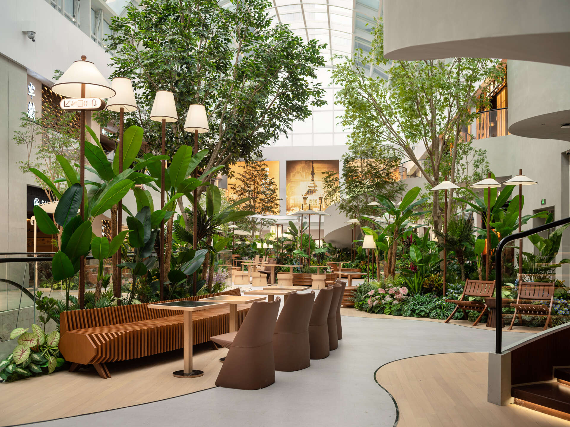 Movement through this plaza is reimagined through softly winding paths that guide visitors under filtered light and between plants. A layout that slows the pace and invites quiet exploration.
