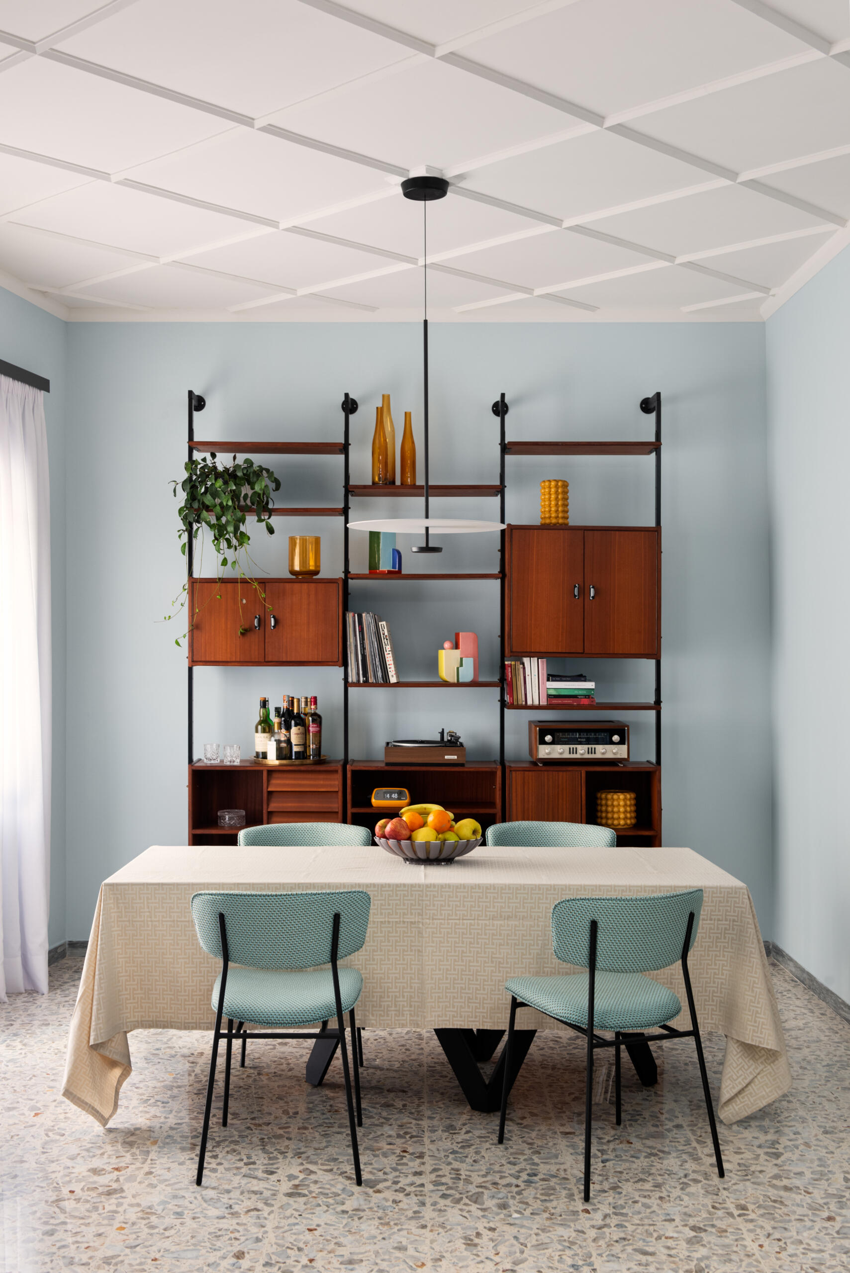Vintage furniture warm up the dining area in this thoughtfully restored 1960s Roman apartment.