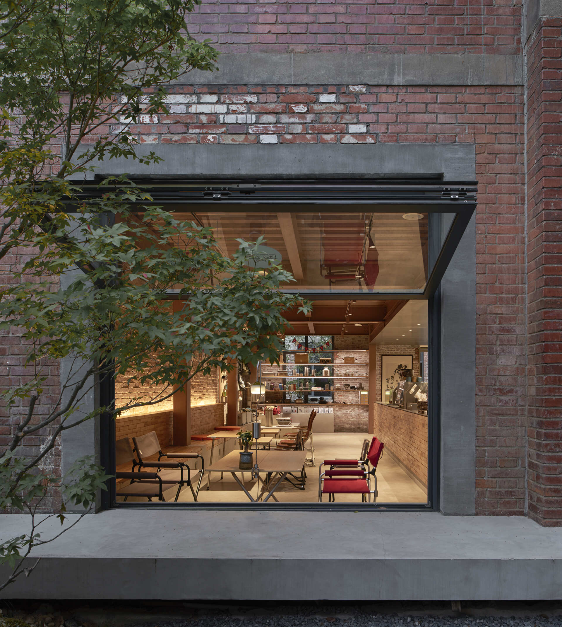 An original 1950s red-brick warehouse was renovated into a modern cafe with two levels.