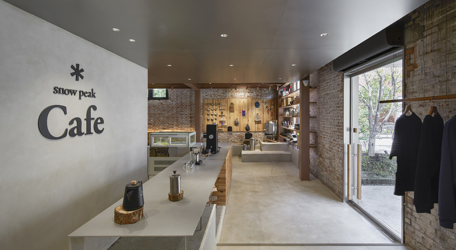 Stepping inside the renovated warehouse, and the central feature of the cafe is a large multi-functional bar that handles coffee service, retail display, and the checkout area.