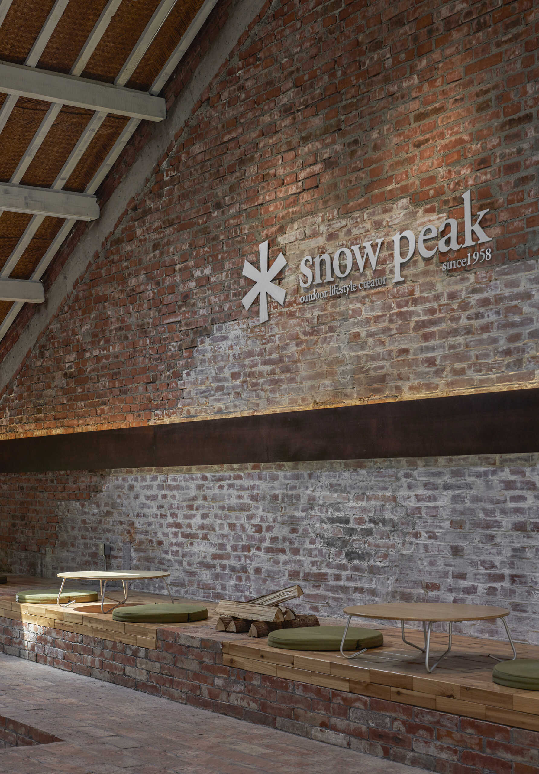 In a modern cafe located inside a renovated red-brick warehouse, there's two levels, with the upper level including stepped seating made from reclaimed brick.