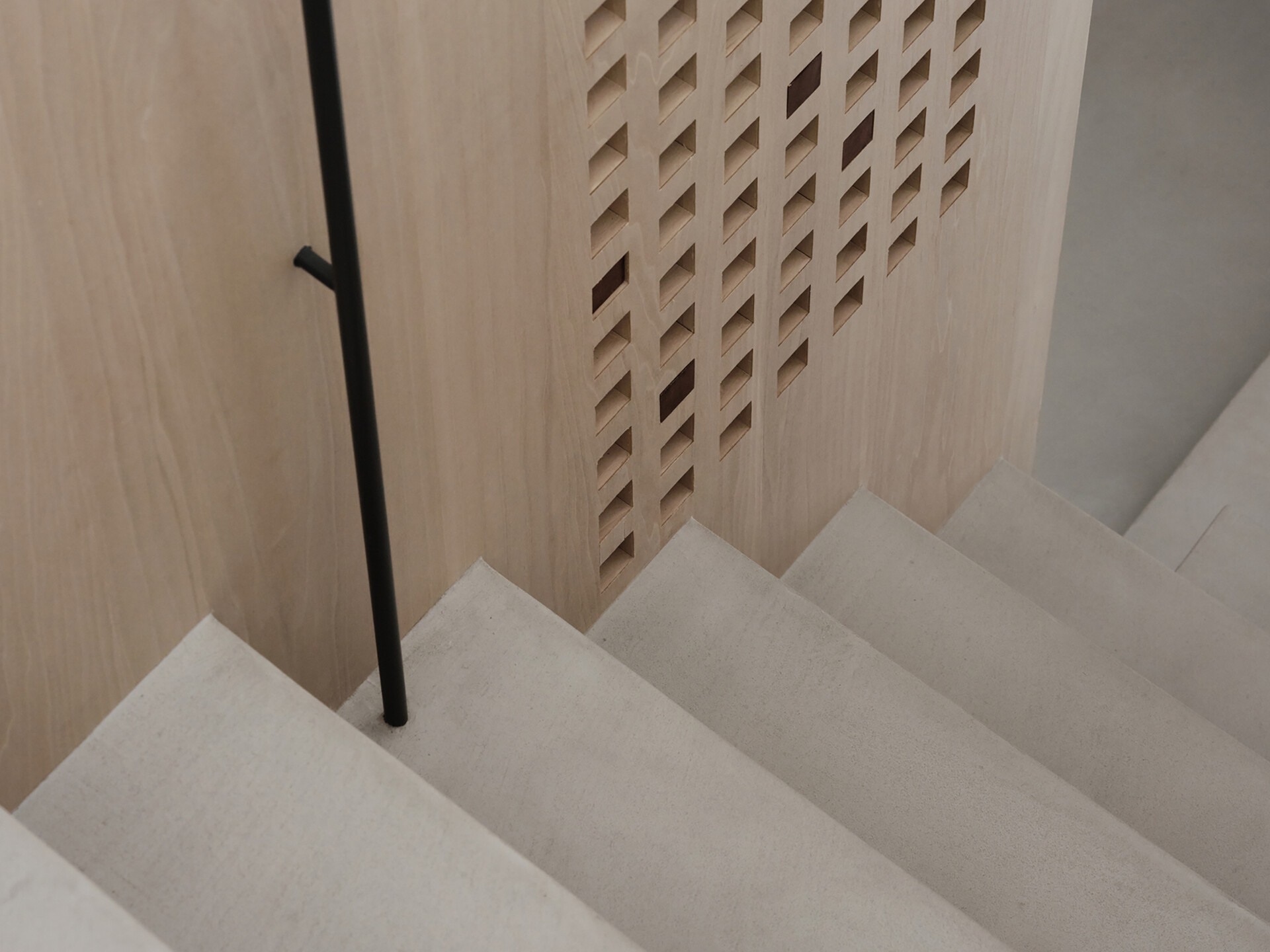This staircase leading to the loft is more than just a means of access, it’s an architectural feature. Rather than feeling bulky, it reads as an extension of the home’s material language. Slim, pale wood treads and light metal framing keep the look airy, while maintaining stability and safety. The stair’s placement also supports the apartment’s “dual circulation” layout, ensuring clear, logical flow between living zones.