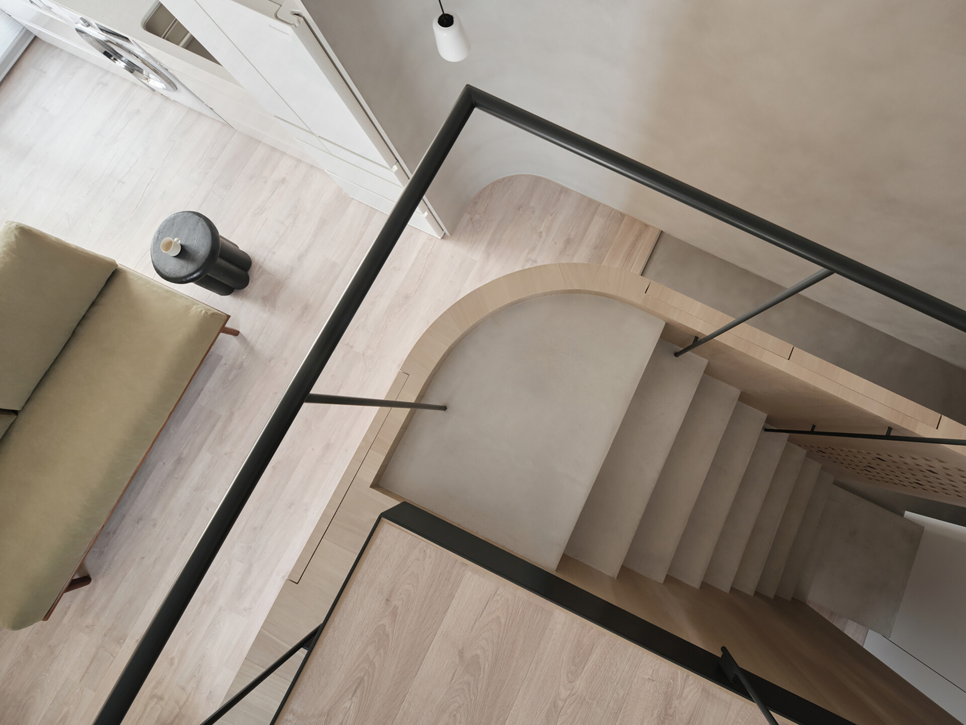 This staircase leading to the loft is more than just a means of access, it’s an architectural feature. Rather than feeling bulky, it reads as an extension of the home’s material language. Slim, pale wood treads and light metal framing keep the look airy, while maintaining stability and safety. The stair’s placement also supports the apartment’s “dual circulation” layout, ensuring clear, logical flow between living zones.