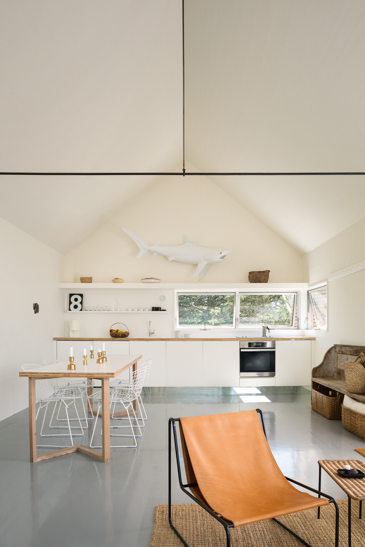 A light-filled kitchen with crisp white cabinets, open shelves, and playful details. Natural textures and soft wood keep it warm and relaxed.