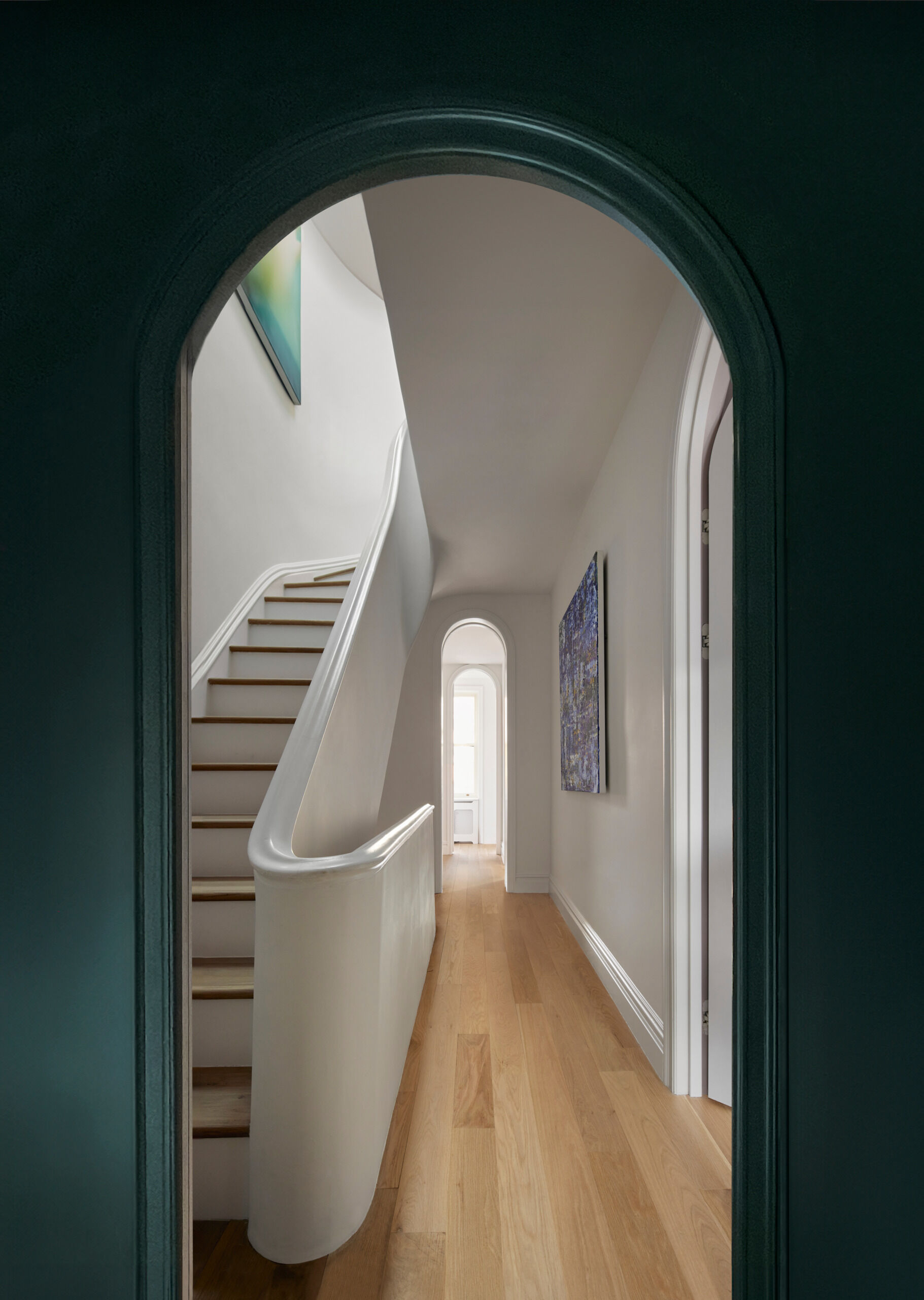 A rebuilt, curving staircase winds through the center of the home, culminating in a sculpted, skylit hall on the top floor.