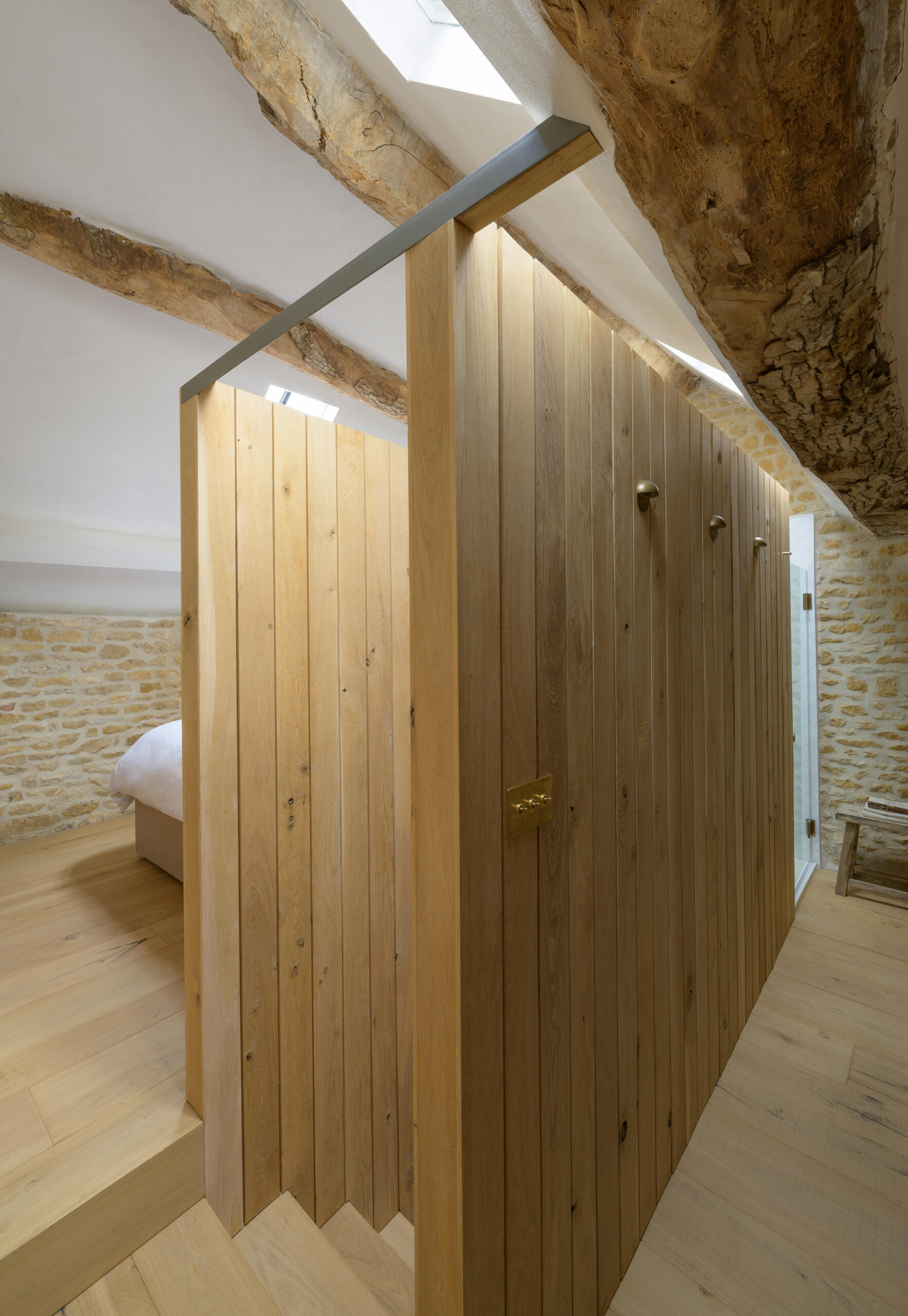 A timber staircase pod is central to the entire layout of this barn conversion. It links the two volumes of the barn, creating a passageway between rooms and housing the new staircase to the first floor. The pod also mediates the level change, helping the house feel cohesive despite the barn’s split levels. Its presence is bold but natural, blending new with old without overwhelming the original structure.