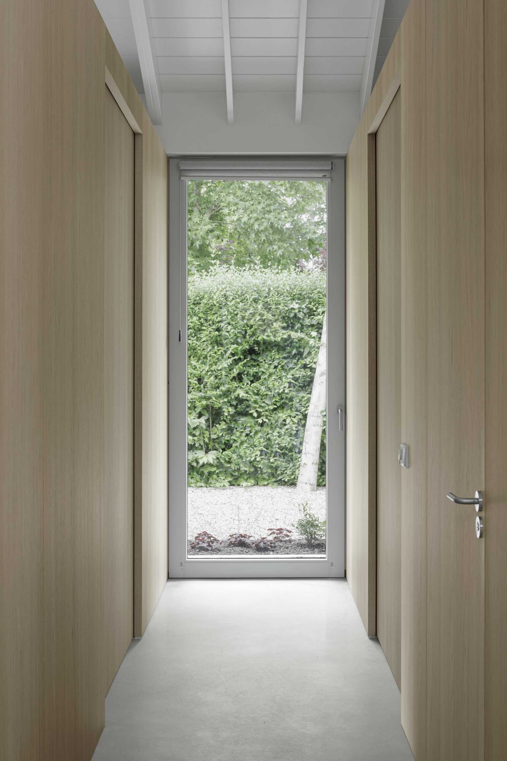 Back inside and off the entryway is a discreet hallway that leads to the bedroom and bathroom. Continuous oak cladding visually leads the way, with no sharp transitions or visual clutter.