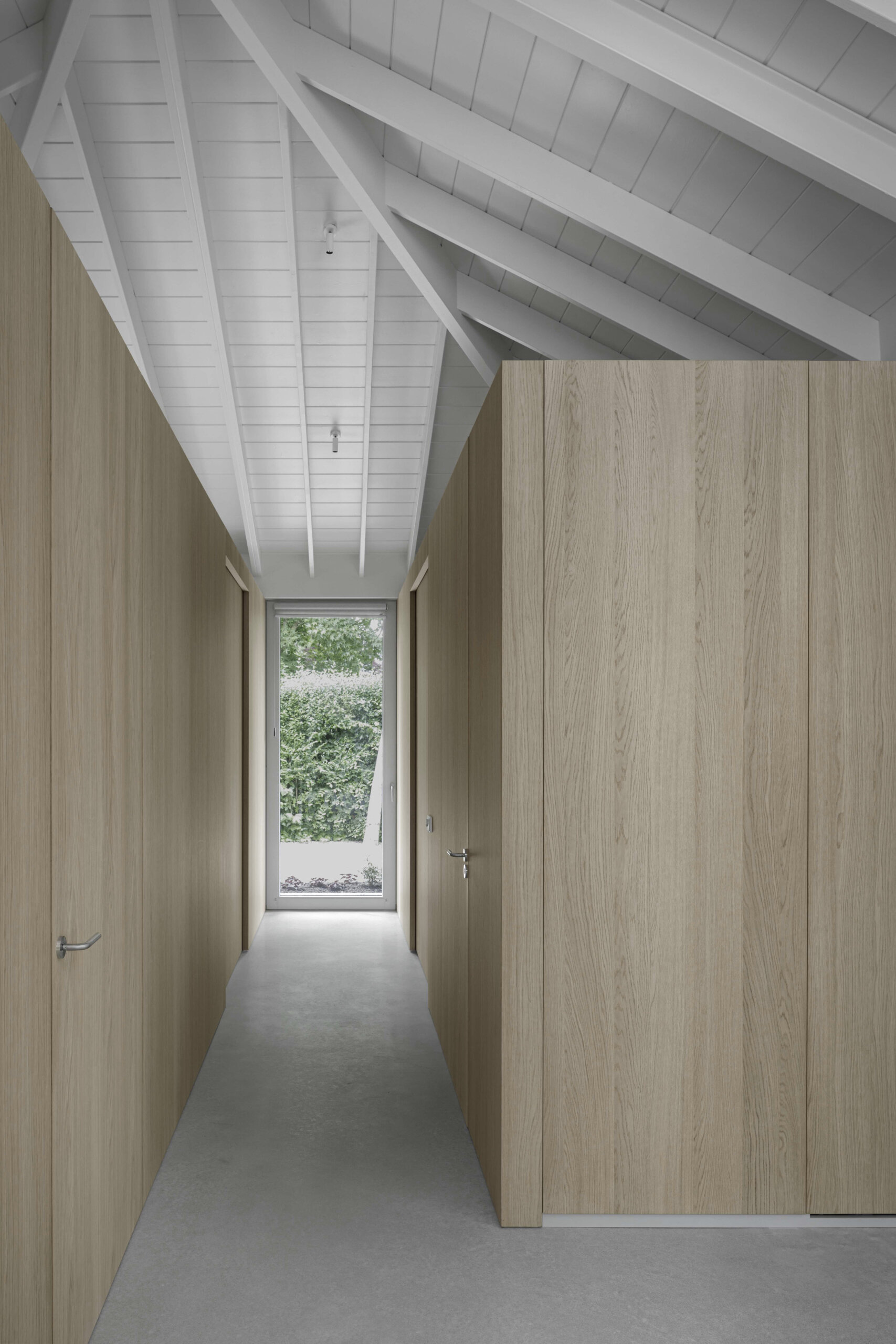 Back inside and off the entryway is a discreet hallway that leads to the bedroom and bathroom. Continuous oak cladding visually leads the way, with no sharp transitions or visual clutter.