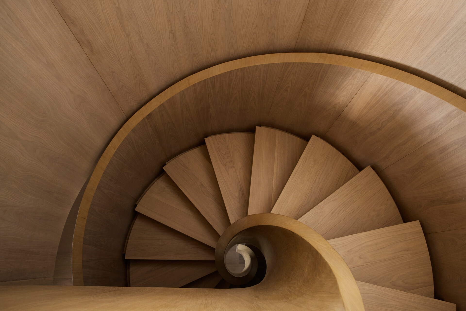 The staircase, originally located in a corner, was relocated to the center of the duplex. Redesigned as a wood spiral, it functions as a sculptural feature that organizes movement between floors while reinforcing the apartment’s sense of fluidity and connection.