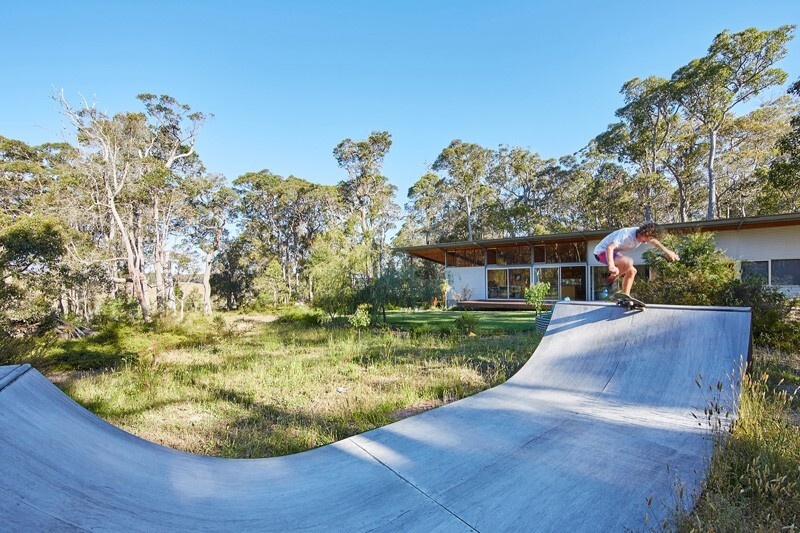 A hand-built skateboard ramp sits beside the home, adding a playful, personal layer to this off-grid retreat.