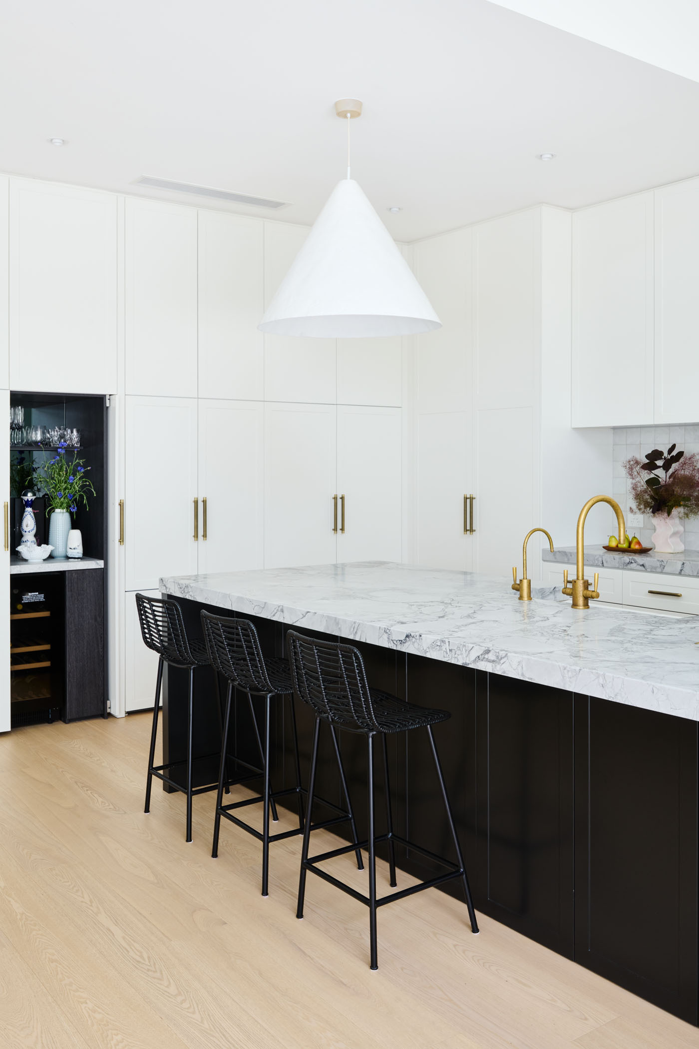 Soft, Scandinavian-inspired details and a minimalist black-and-white palette create a calm, functional kitchen that opens directly to the garden.