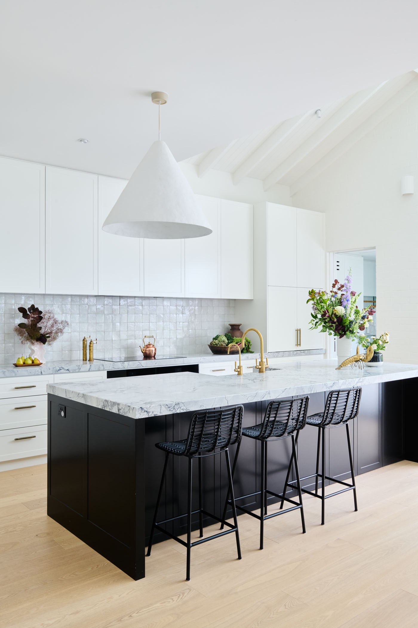 Soft, Scandinavian-inspired details and a minimalist black-and-white palette create a calm, functional kitchen that opens directly to the garden.
