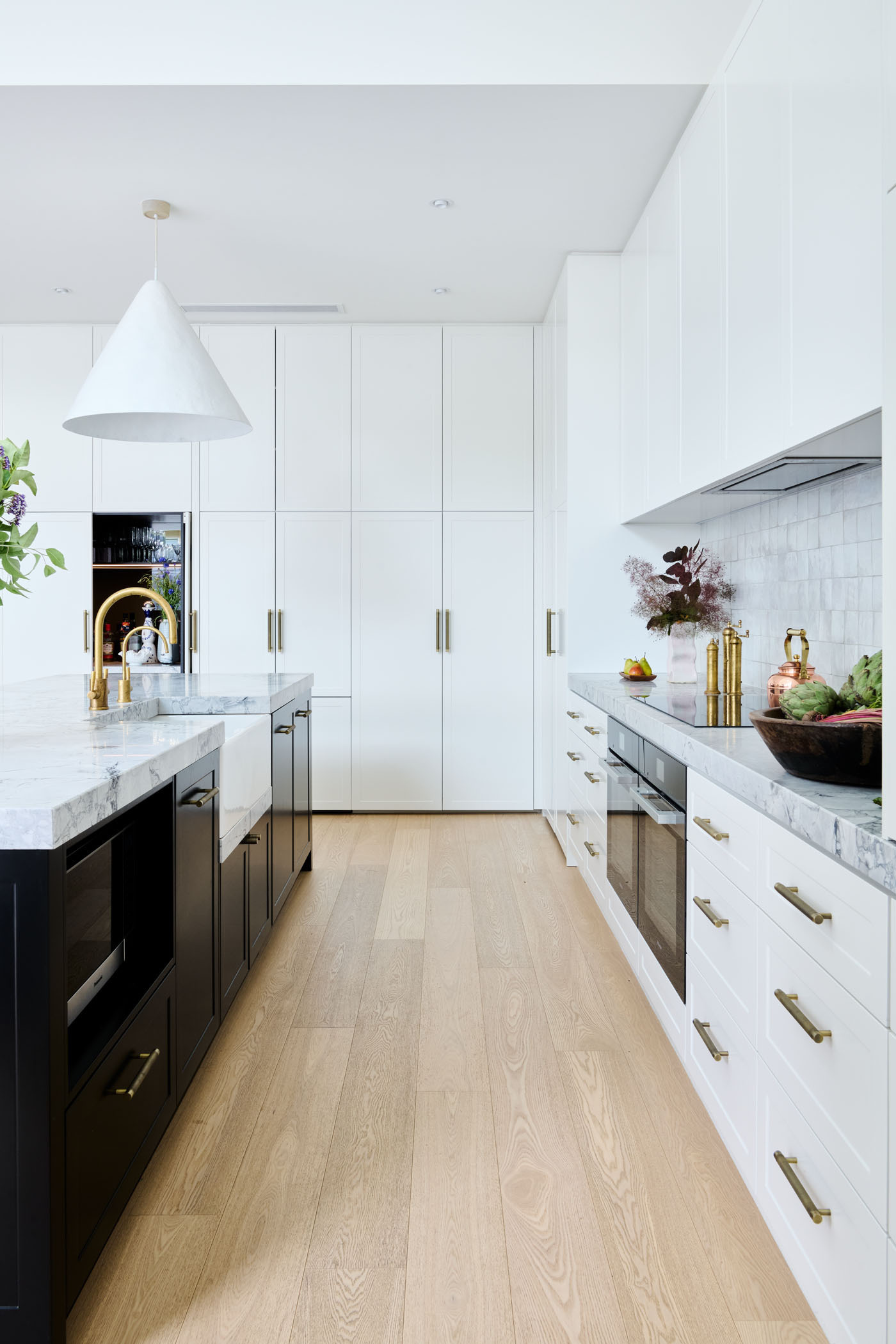 Soft, Scandinavian-inspired details and a minimalist black-and-white palette create a calm, functional kitchen that opens directly to the garden.