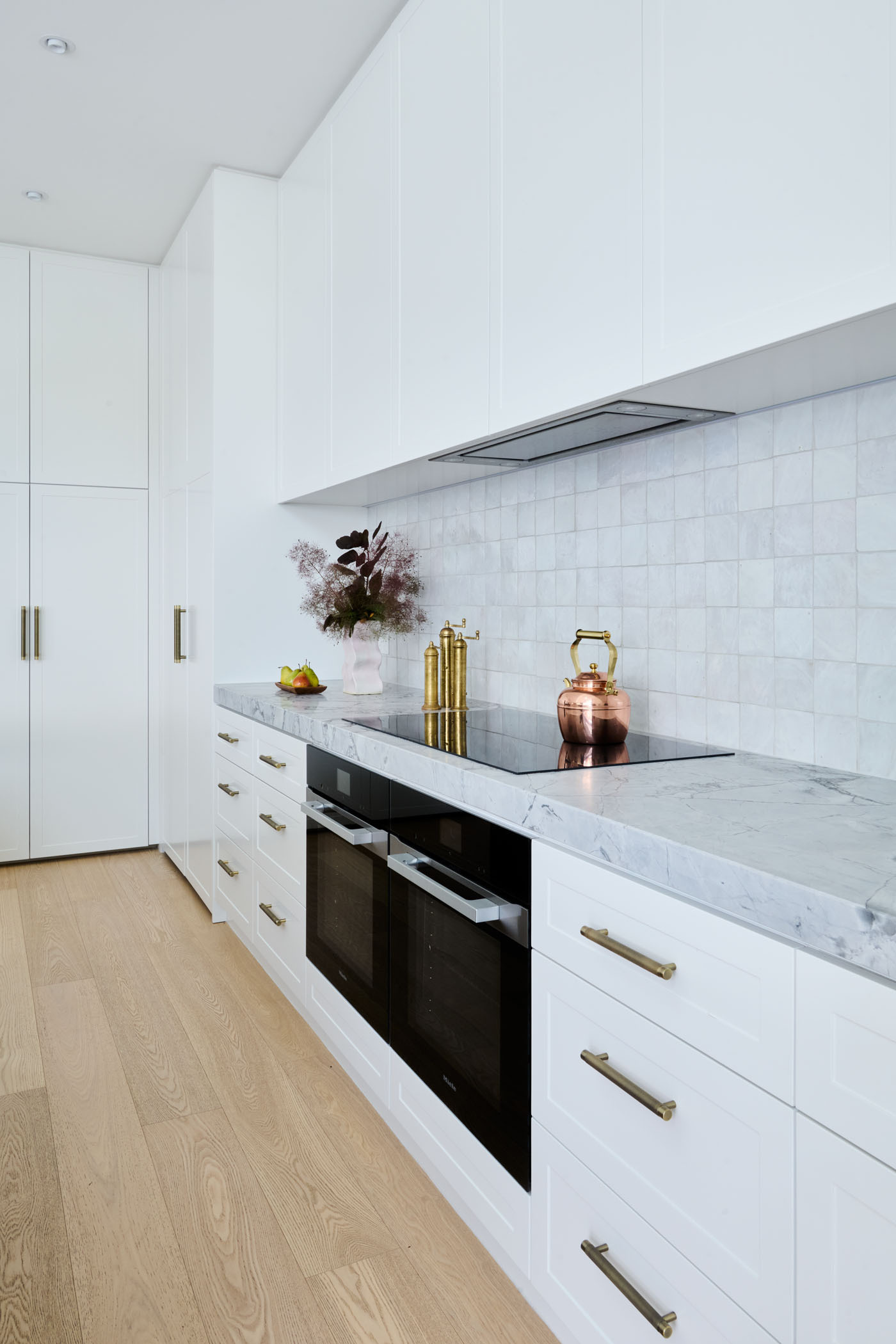 Soft, Scandinavian-inspired details and a minimalist black-and-white palette create a calm, functional kitchen that opens directly to the garden.