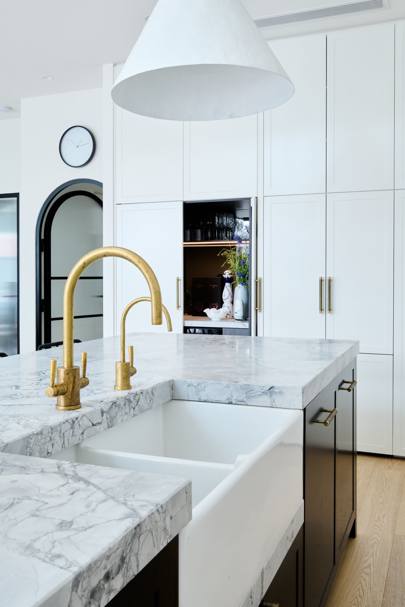 Soft, Scandinavian-inspired details and a minimalist black-and-white palette create a calm, functional kitchen that opens directly to the garden.