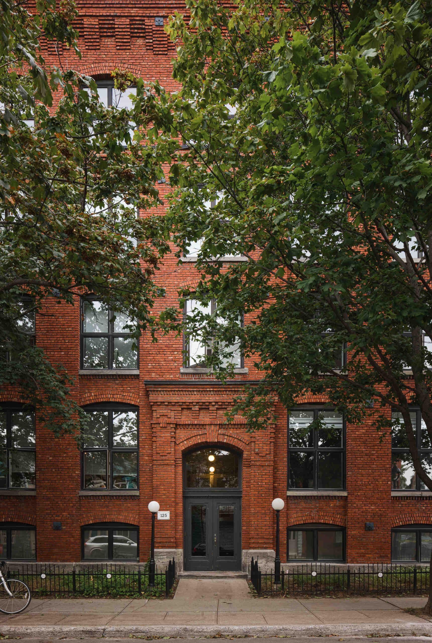 Once a textile mill and Campbell’s soup factory, this 19th-century Montreal building now houses a refined loft that honors its industrial past with exposed timber beams, brick arches, and bold modern insertions. A striking blend of history and contemporary design.