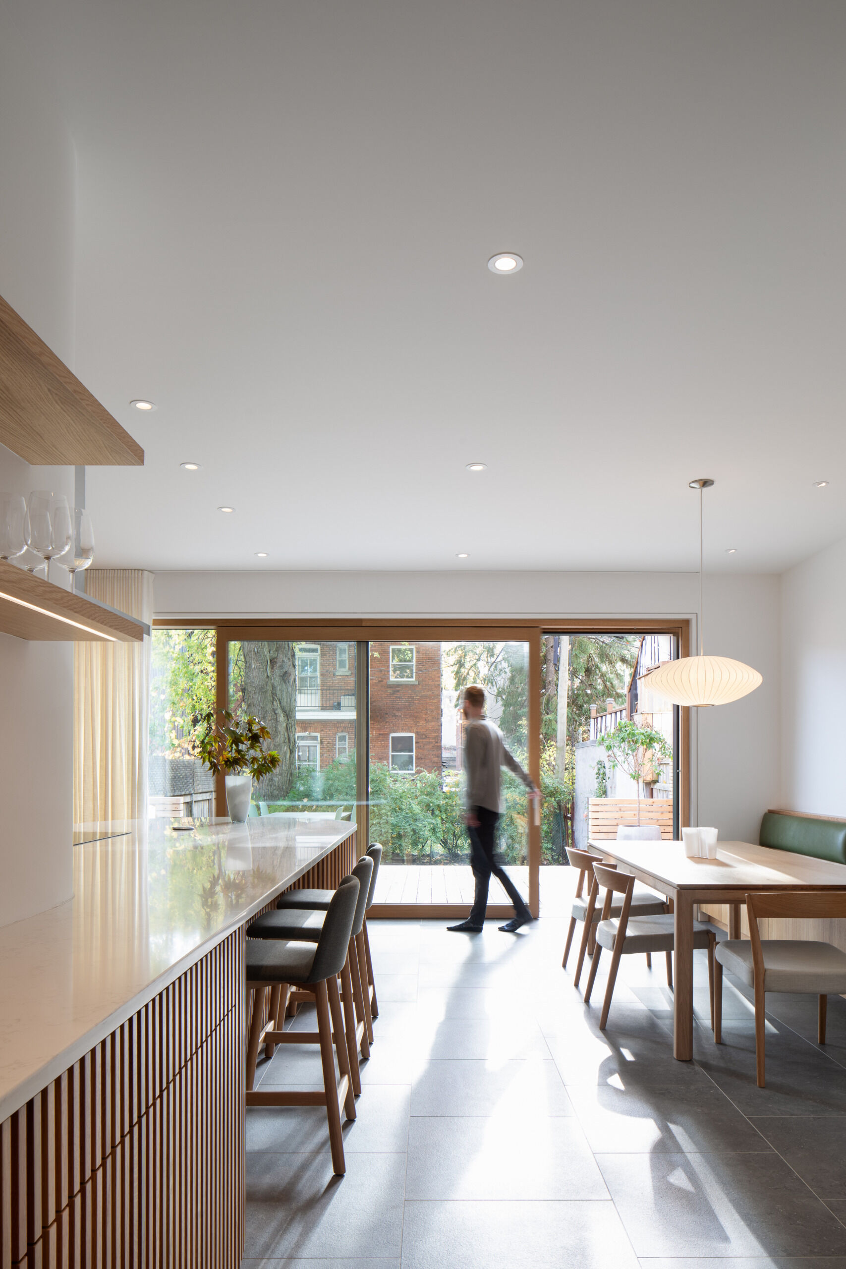 This built-in oak banquette anchors a cozy dining area, with rounded joinery, hidden storage, and soft natural light enhancing the sense of calm and connection.