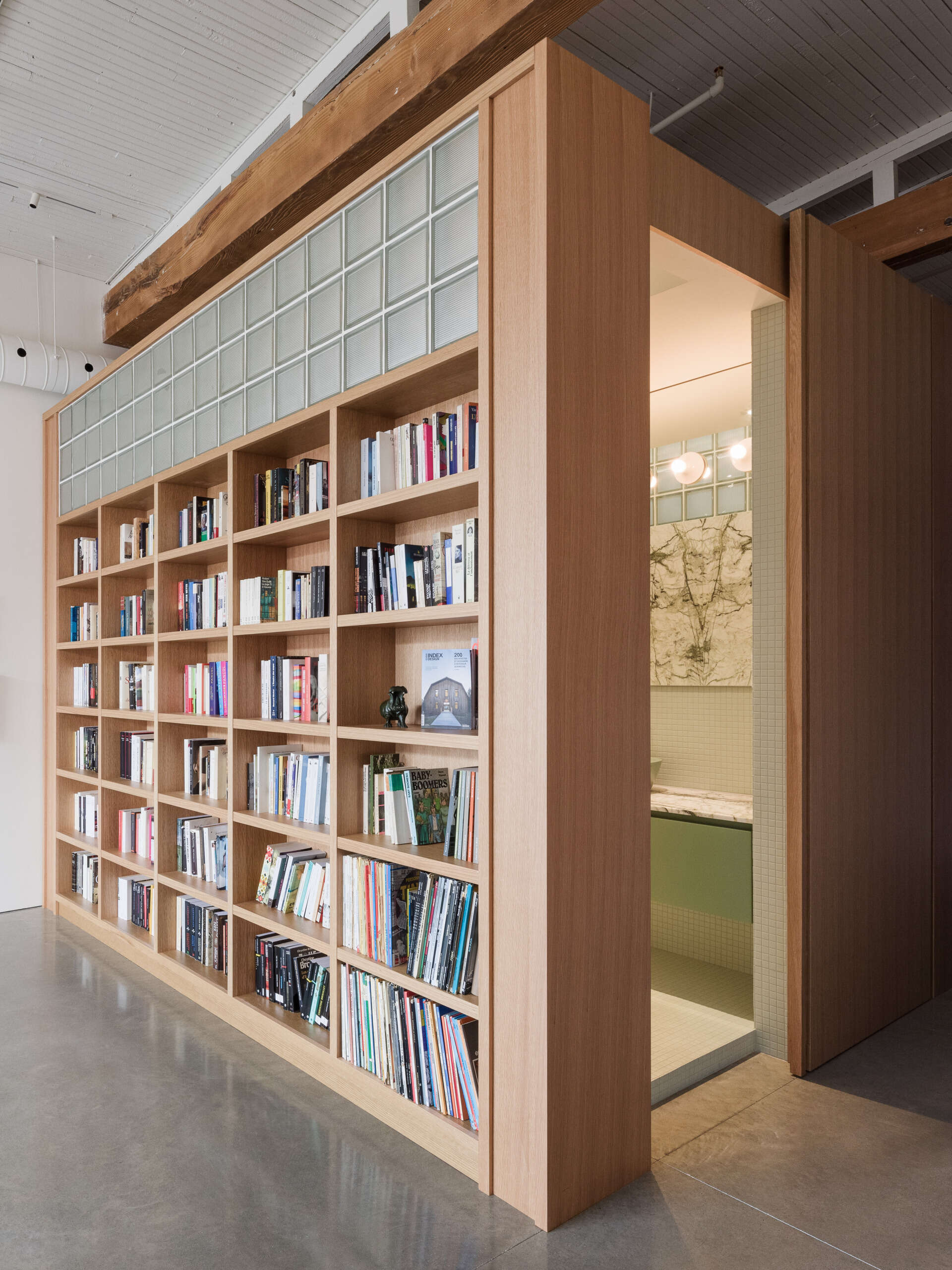 Built-in shelves blend seamlessly into architectural oak volumes, offering storage and structure while keeping the visual flow calm and cohesive.