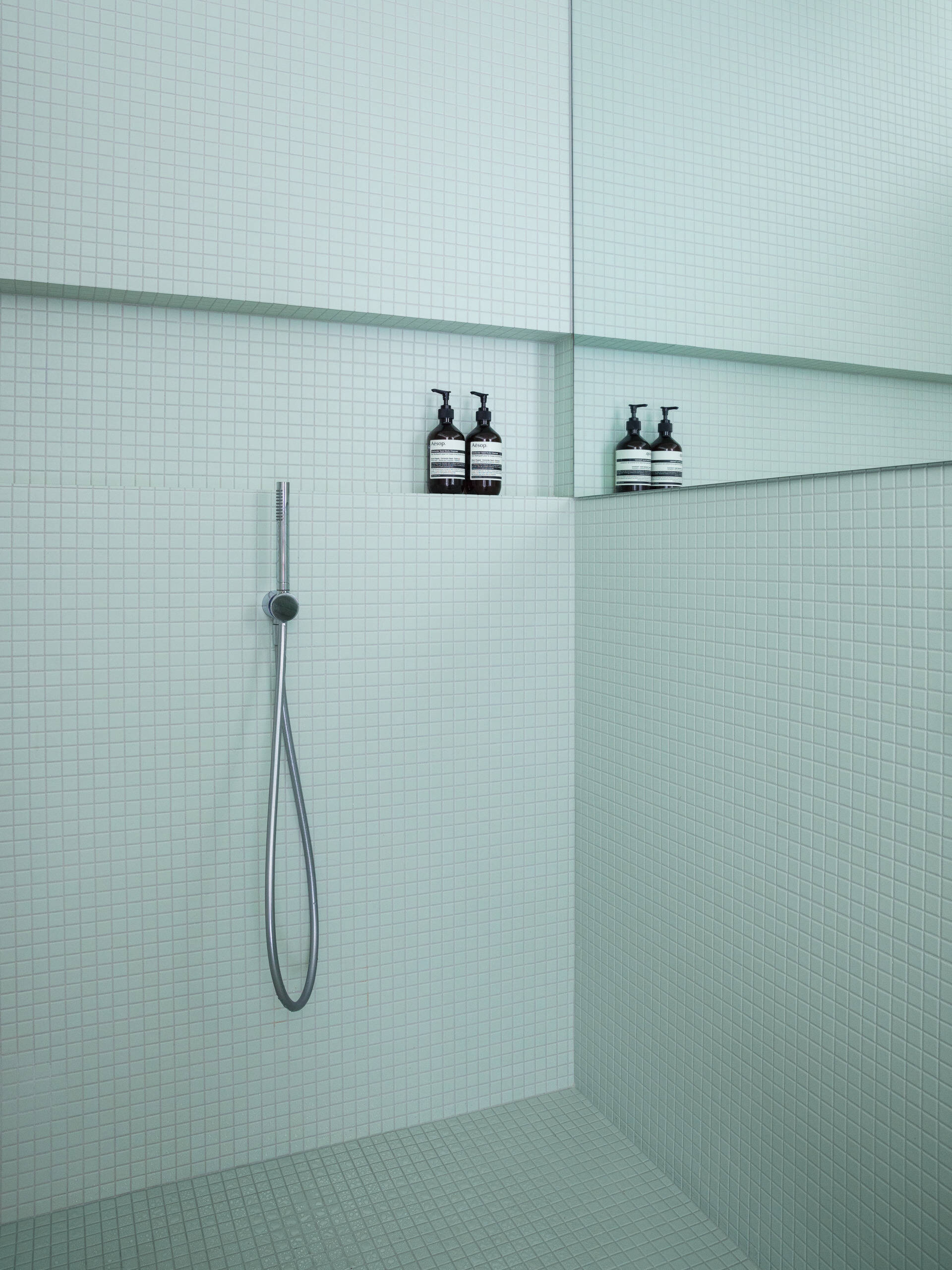 Calacatta verde marble, soft tile, and retro glass blocks bring luxury and light into this modern Montreal bathroom with timeless flair.