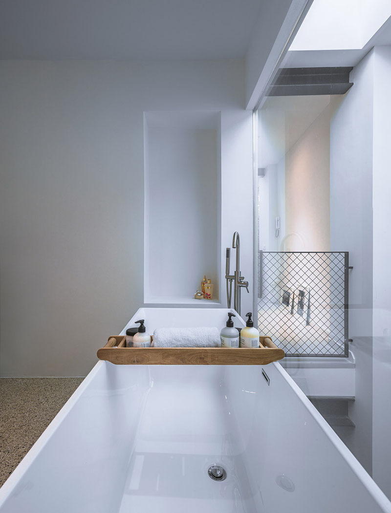 The bathroom makes the most of its place inside the wooden volume. It’s private but not shut off, with lines of sight stretching into the void and even out to the sky. Soaking in the tub, you might spot a bird overhead or catch the shift in afternoon light through the picture window.