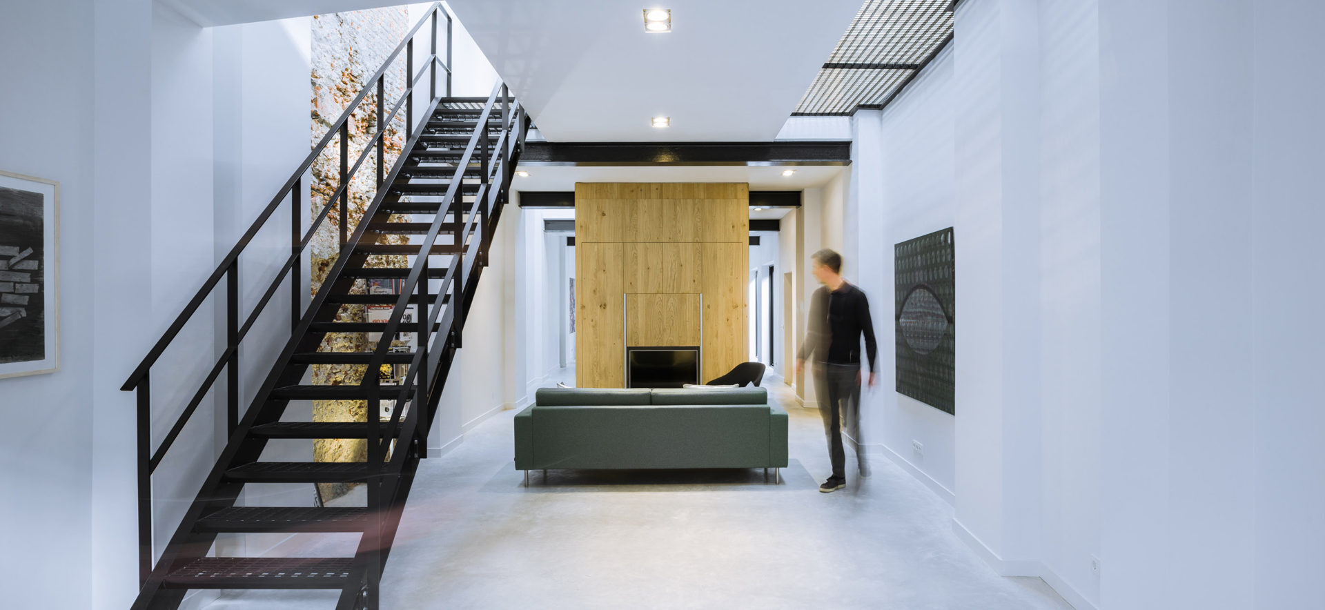 This living area blends openness and calm, with upper-level voids letting daylight spill deep into the space below.