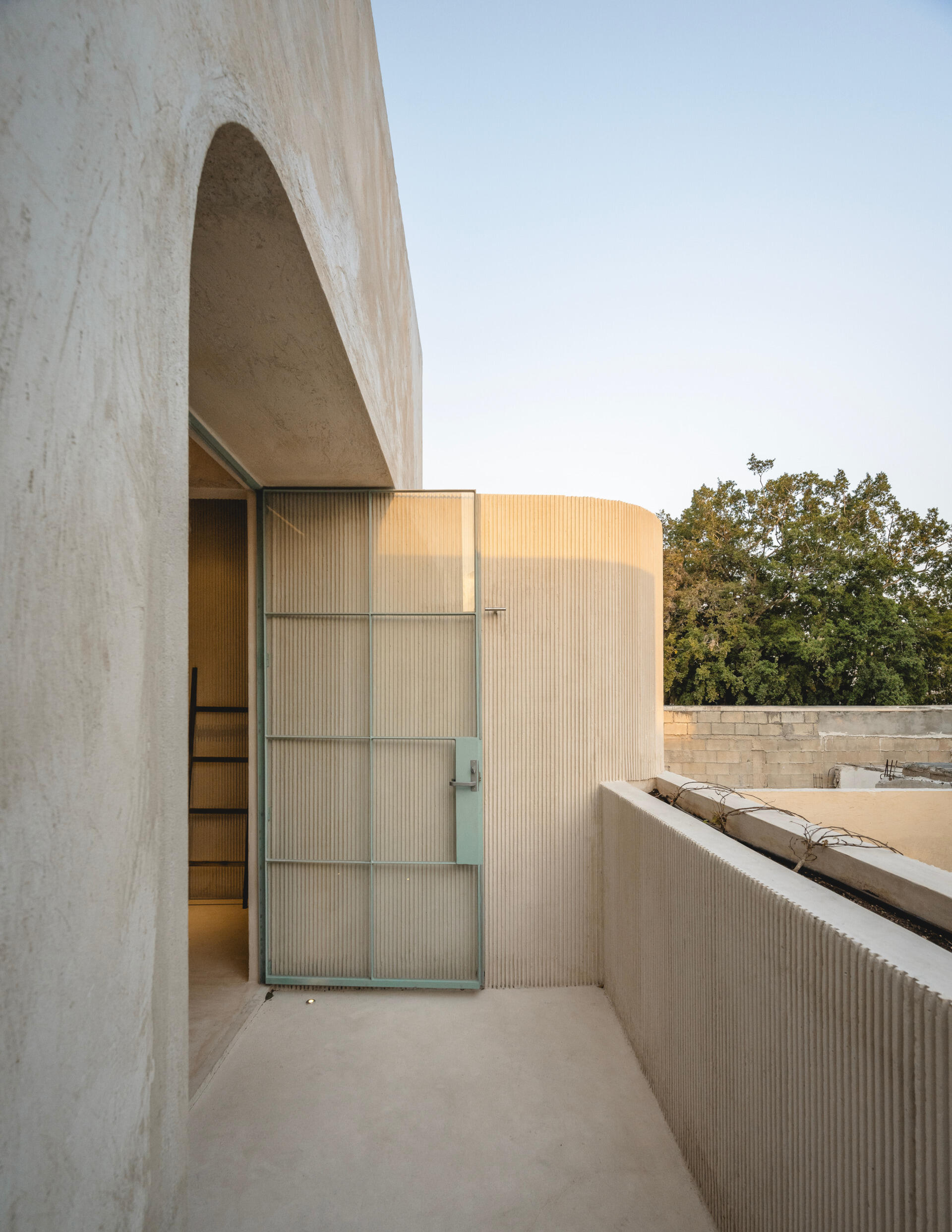 Upstairs, glass walls and doors, framed in slender steel and painted in a sky-blue tone, add a sense of transparency and lightness, opening each room to the patios and gardens beyond.