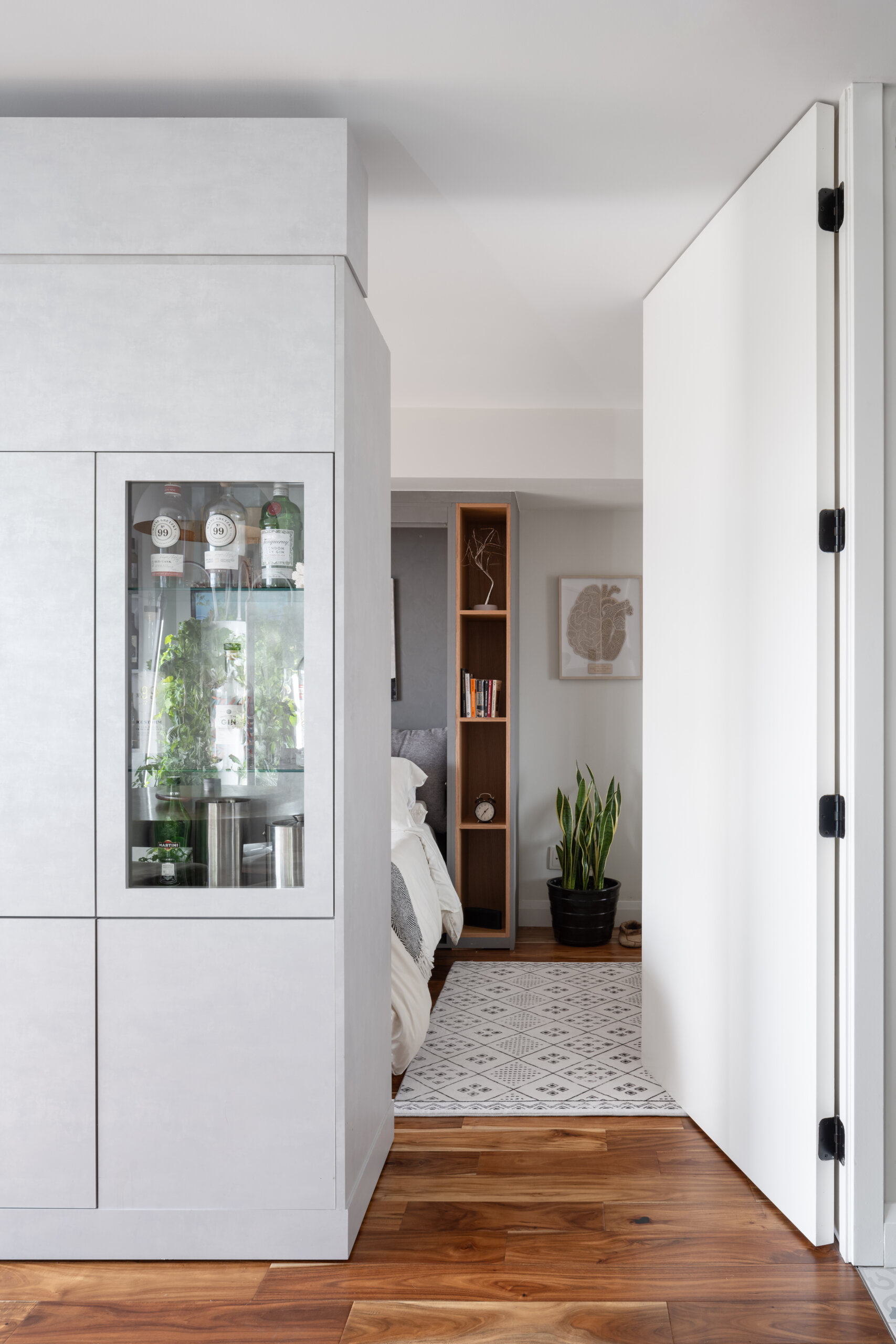 A modern apartment has clever movable walls, packed with storage, a desk, and entertainment features. Behind the walls is a space that gets transformed into a bedroom.