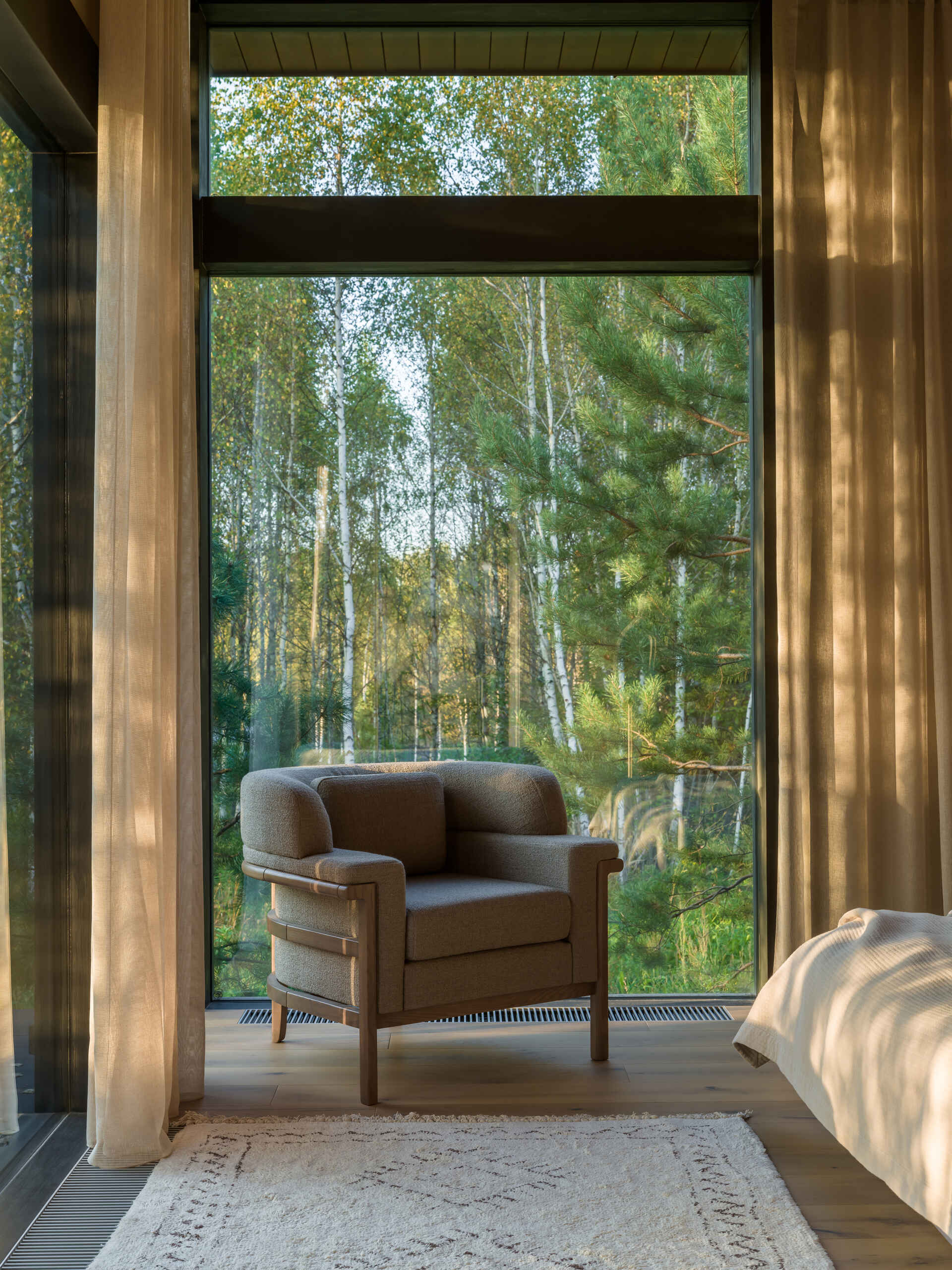 Textured stone, ribbed wood, and clean-lined furniture define this light-filled bedroom with panoramic views and a calming material palette.