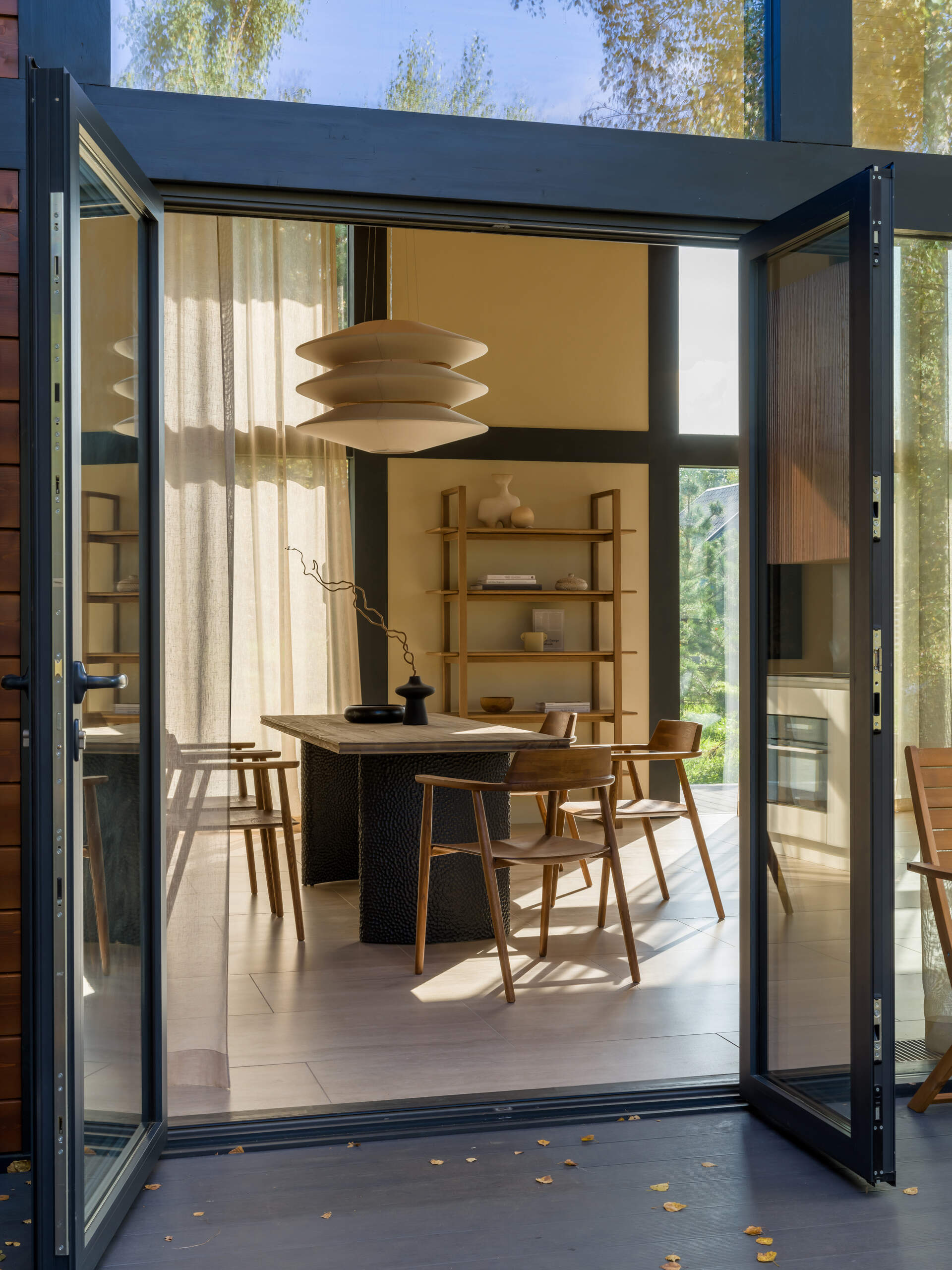 Two terraces offer options: one set for open-air dining, the other tucked into birch trees for quiet moments on curved lounge chairs.