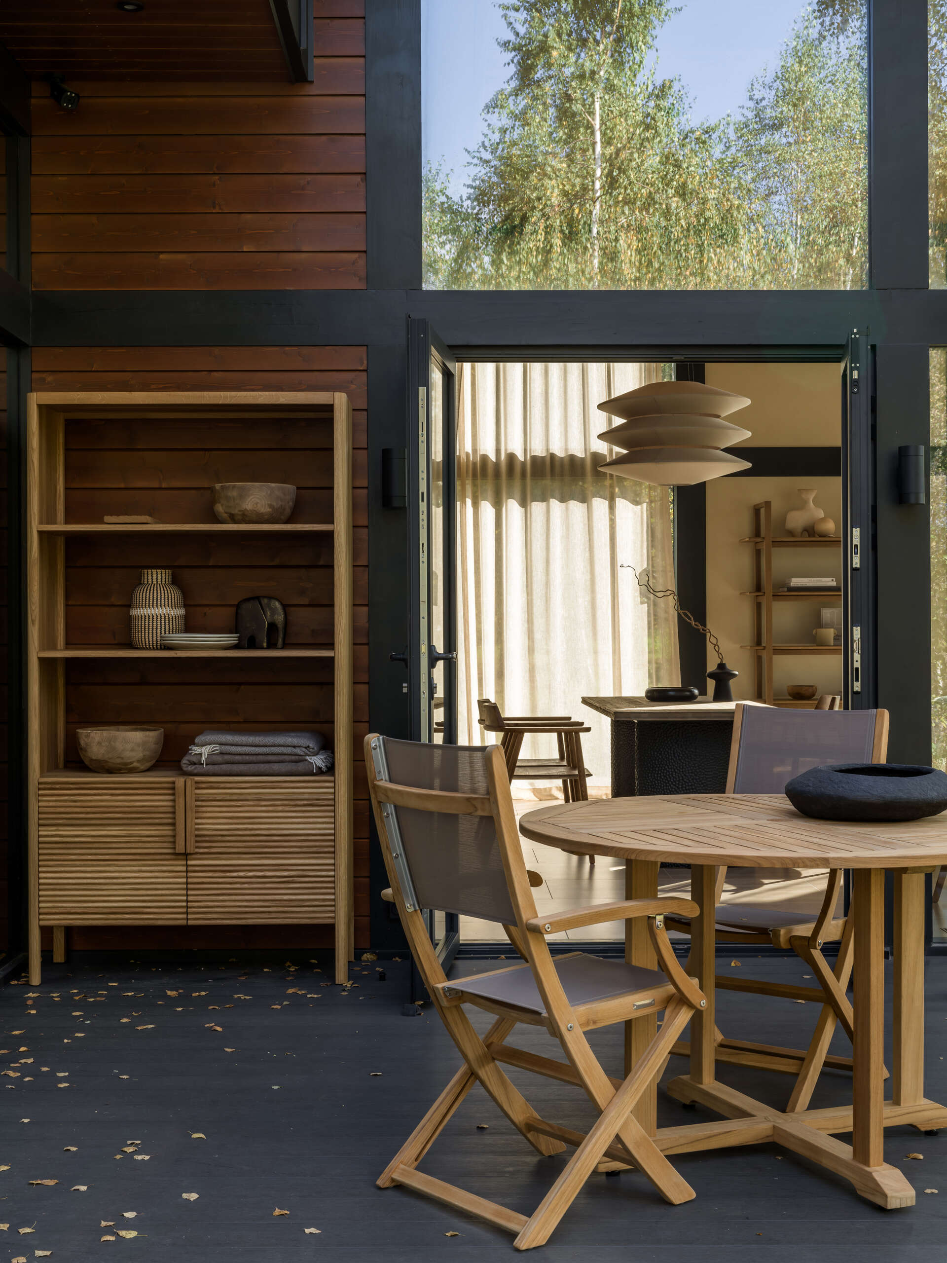 Two terraces offer options: one set for open-air dining, the other tucked into birch trees for quiet moments on curved lounge chairs.