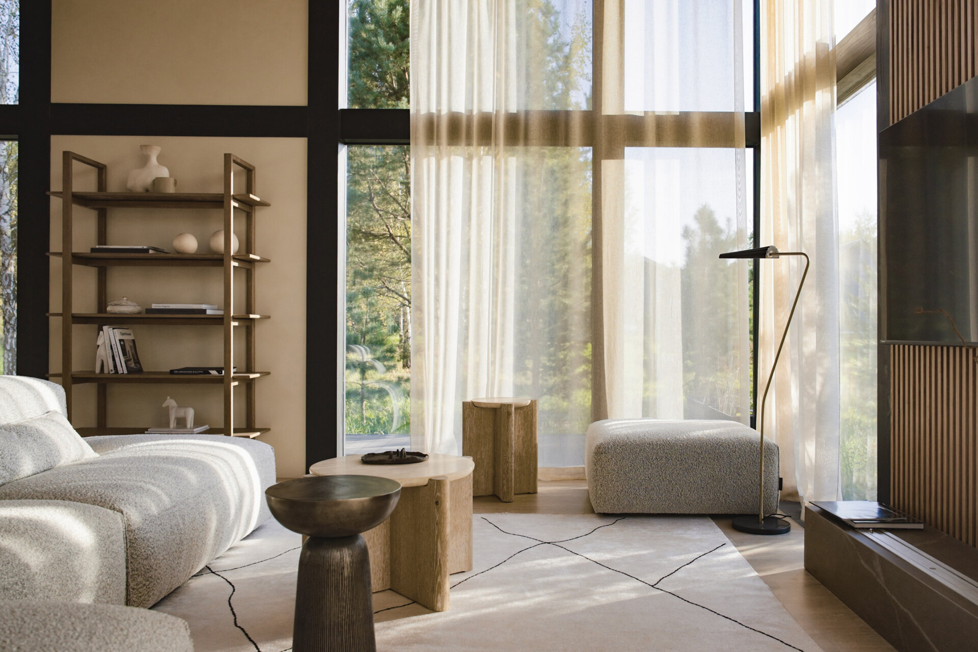 A modular sofa and stone-inspired coffee table bring softness and structure to this living room, framed by views of the surrounding landscape.