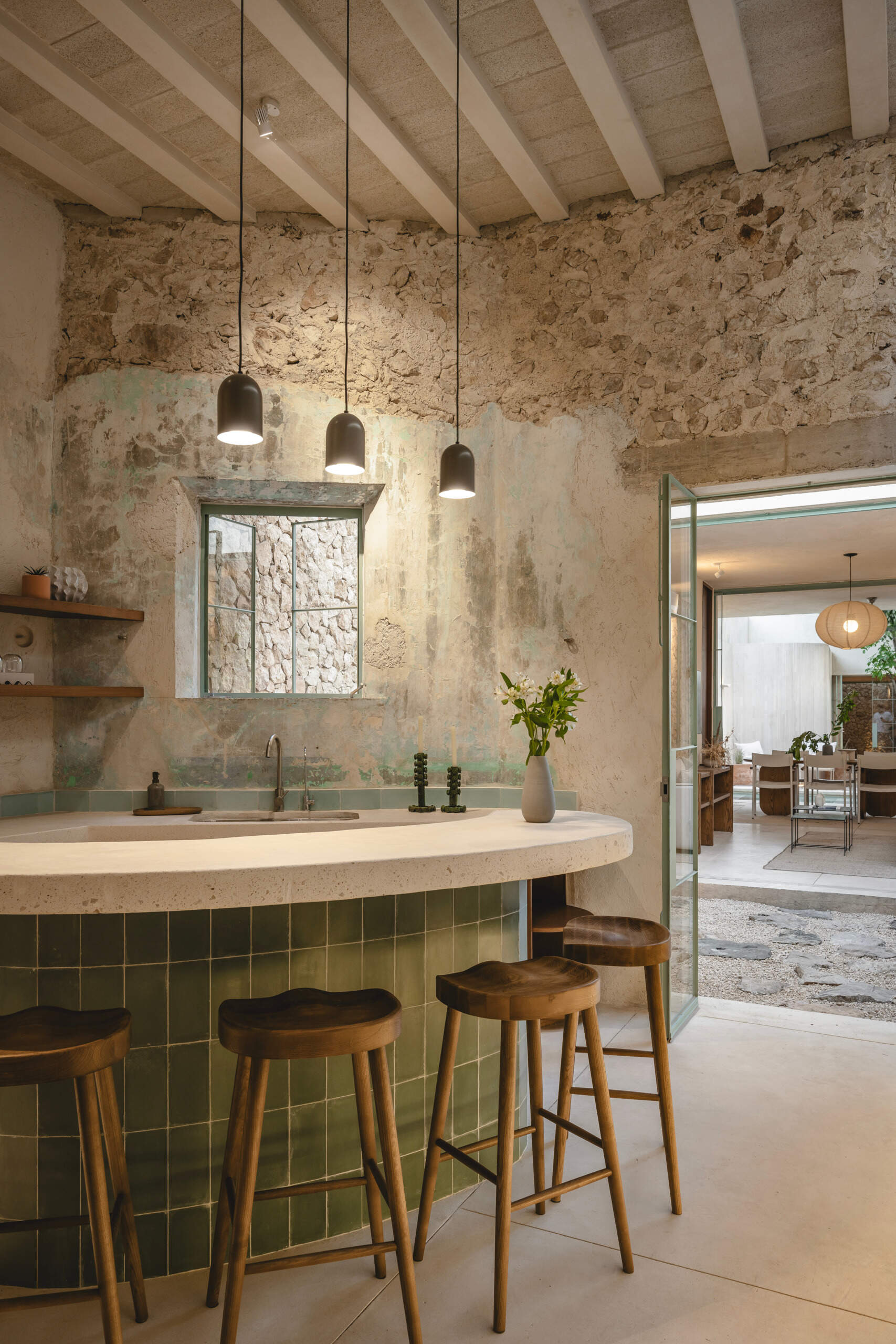 Set just beyond the entrance garden, the kitchen anchors the social core of the home. It is designed as an open, welcoming space that flows effortlessly into the living area and the central patio beyond.