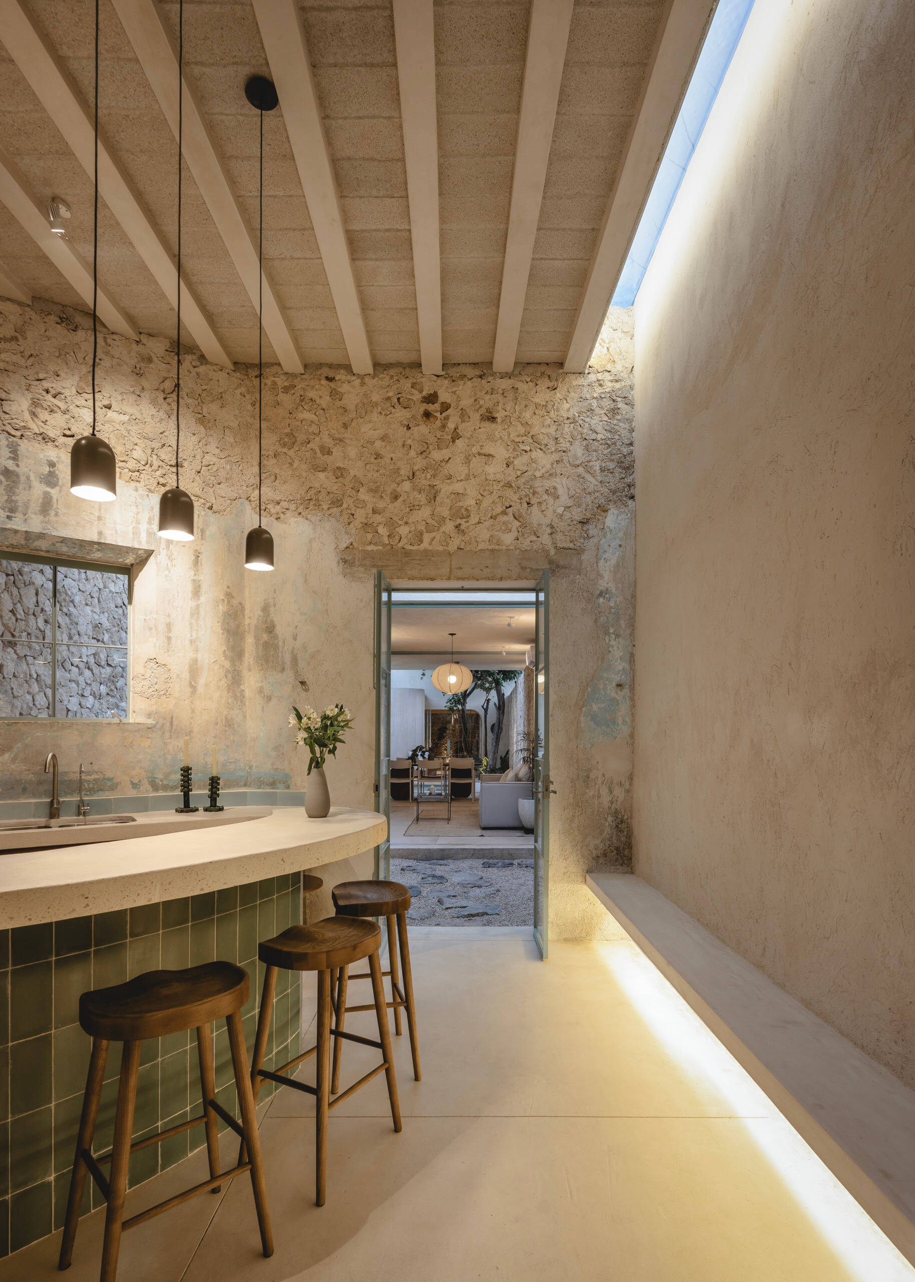 Set just beyond the entrance garden, the kitchen anchors the social core of the home. It is designed as an open, welcoming space that flows effortlessly into the living area and the central patio beyond.
