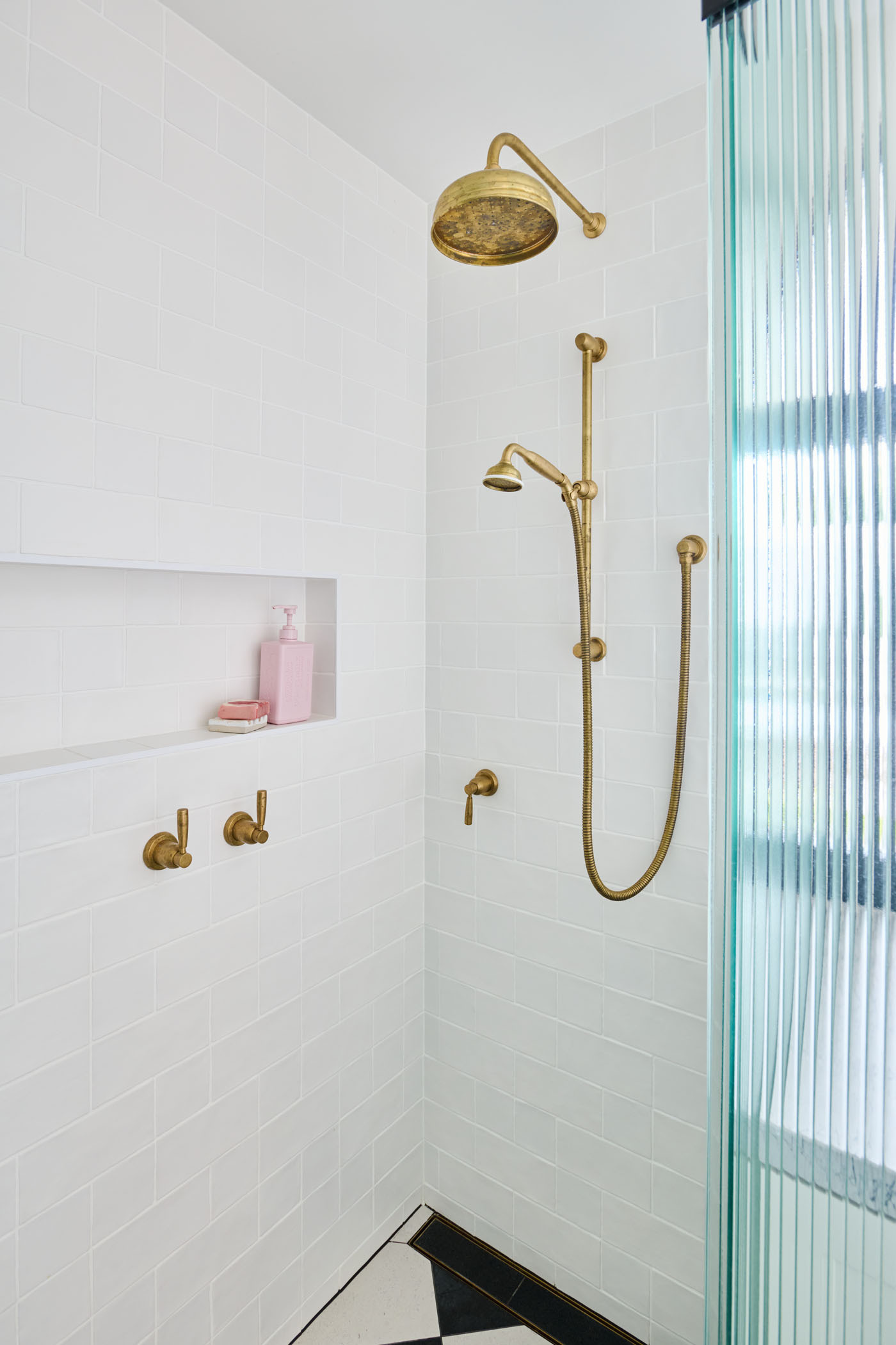 The checkerboard floor in this combined bathroom and laundry room adds a playful twist to the otherwise minimalist interiors. A perfect example of functional design with personality.