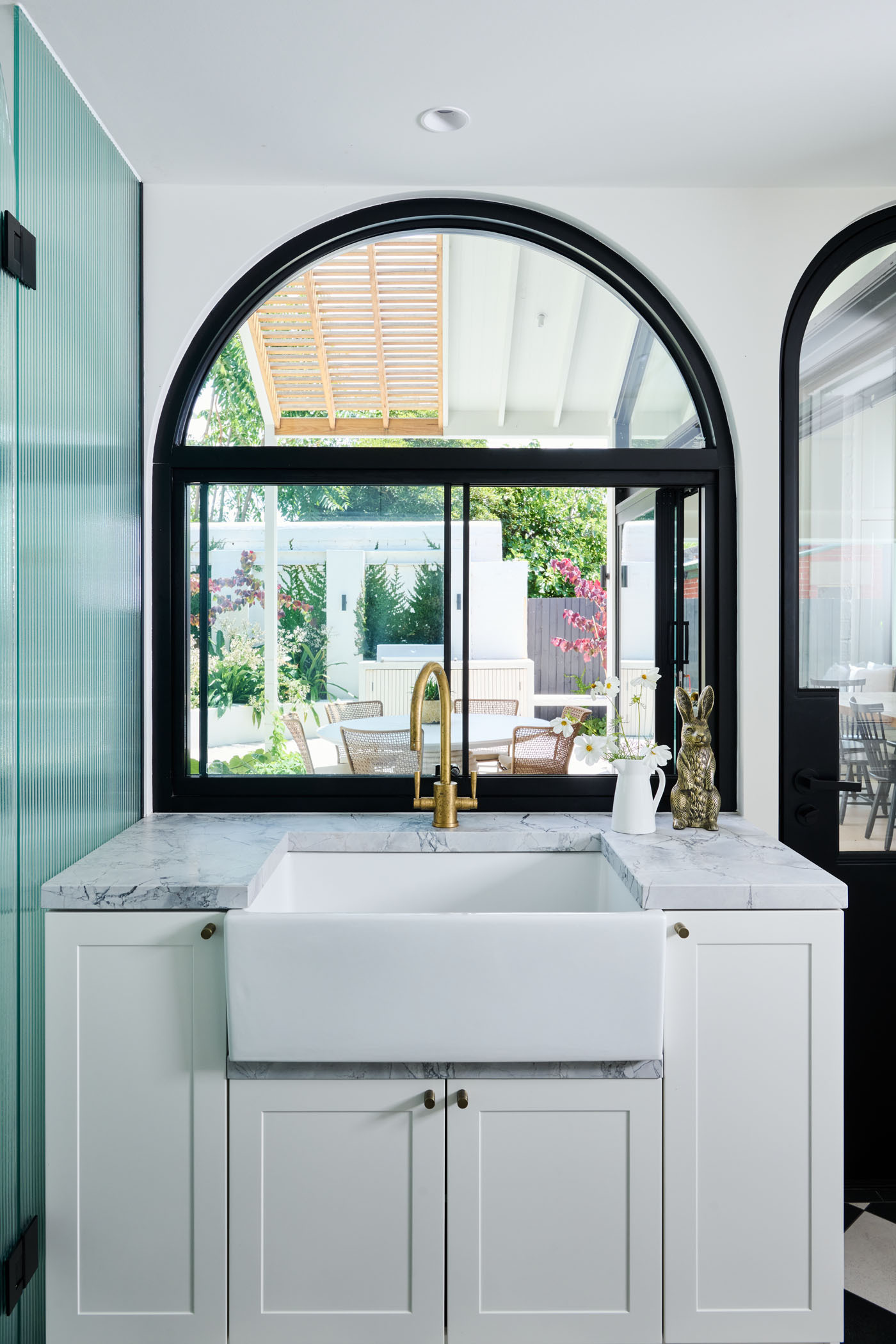The checkerboard floor in this combined bathroom and laundry room adds a playful twist to the otherwise minimalist interiors. A perfect example of functional design with personality.