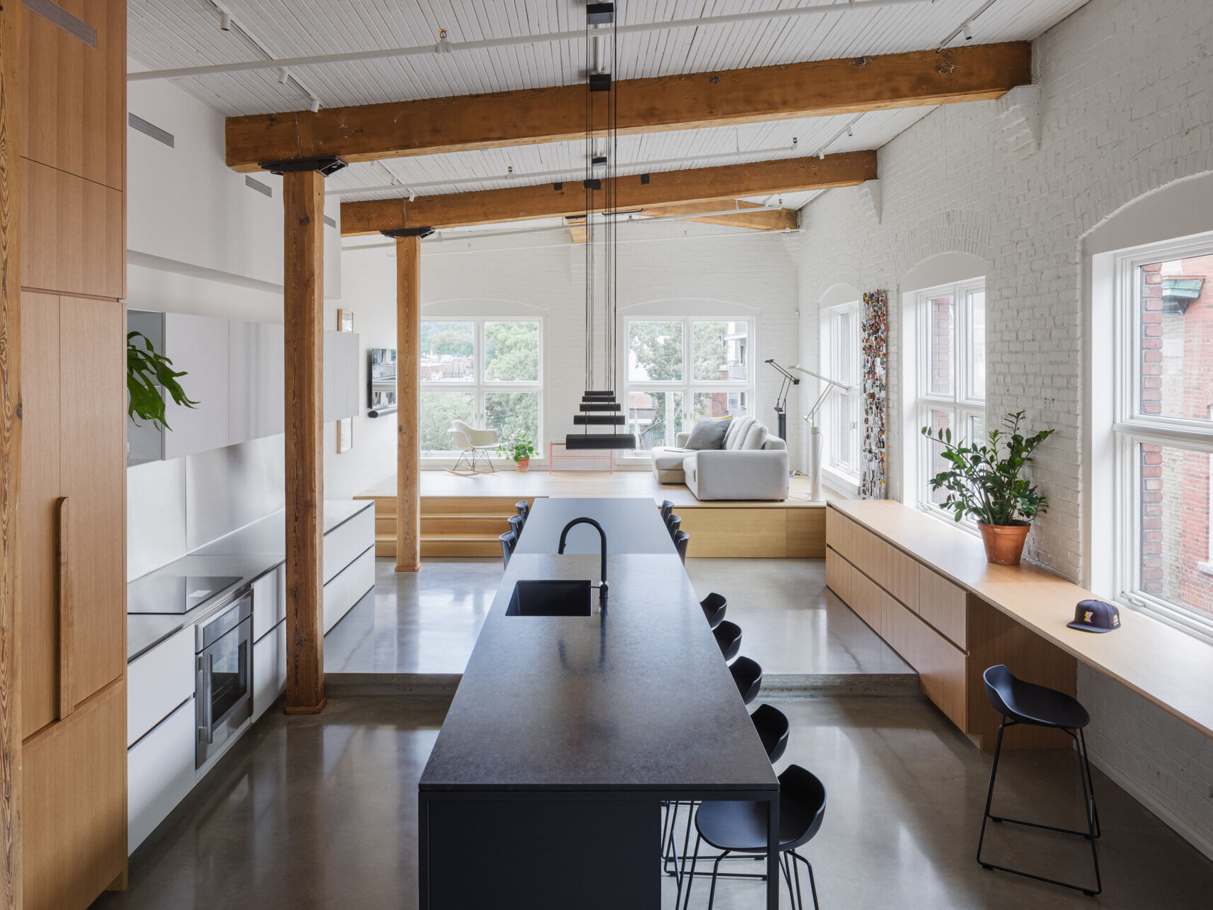 A Montreal loft where industrial history meets warm minimalism. White oak volumes and original brick details create a space that's both raw and refined.