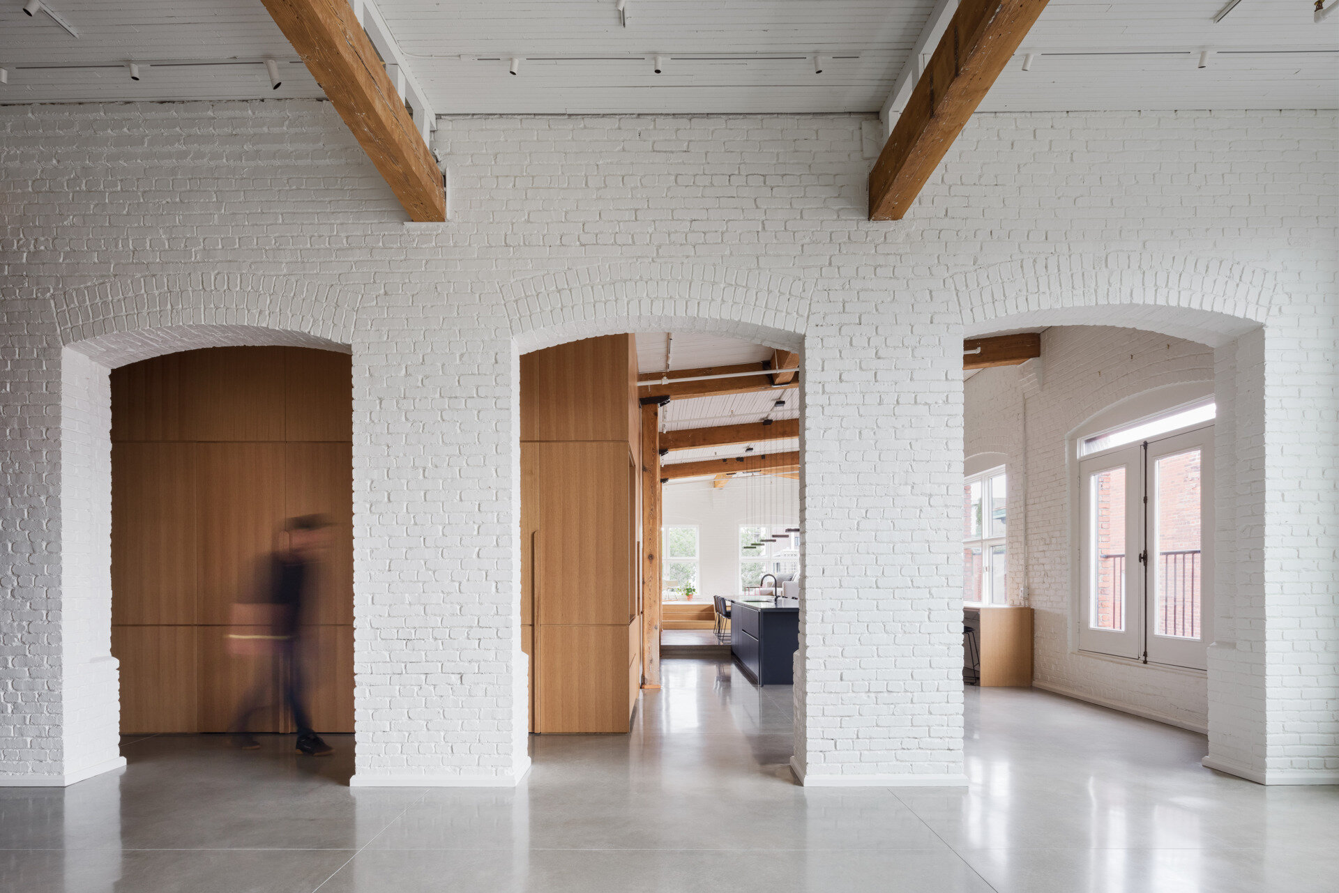A Montreal loft where industrial history meets warm minimalism. White oak volumes and original brick details create a space that's both raw and refined.